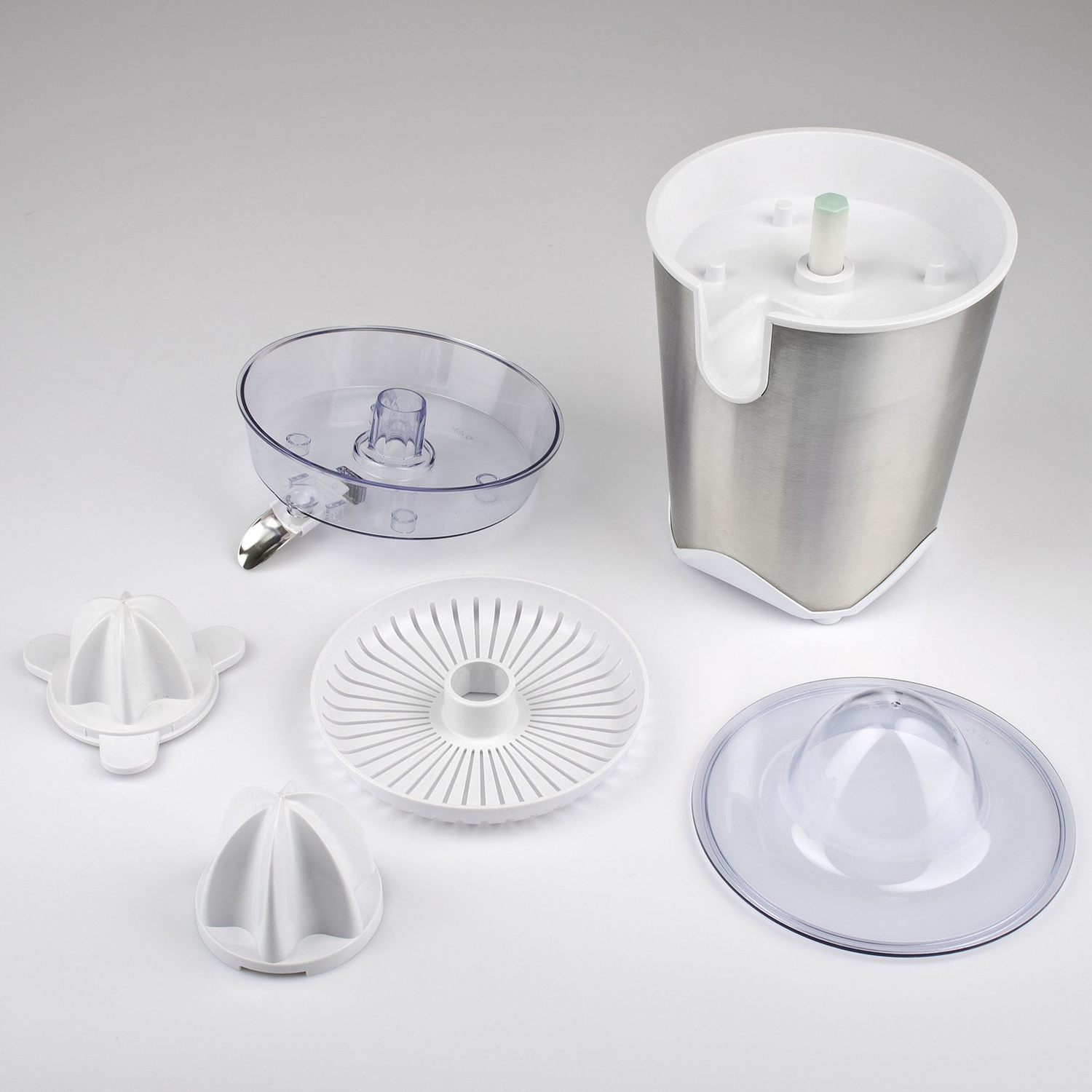 Parti di spremiagrumi: base in acciaio inox, parti in plastica trasparente, colini e alesatori bianchi e un coperchio in plastica trasparente su una superficie bianca.