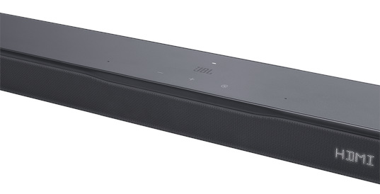 Czarny soundbar JBL. Ma logo JBL i przyciski sterowania na górze. Przód ma siatkę. HDMI jest widoczne.