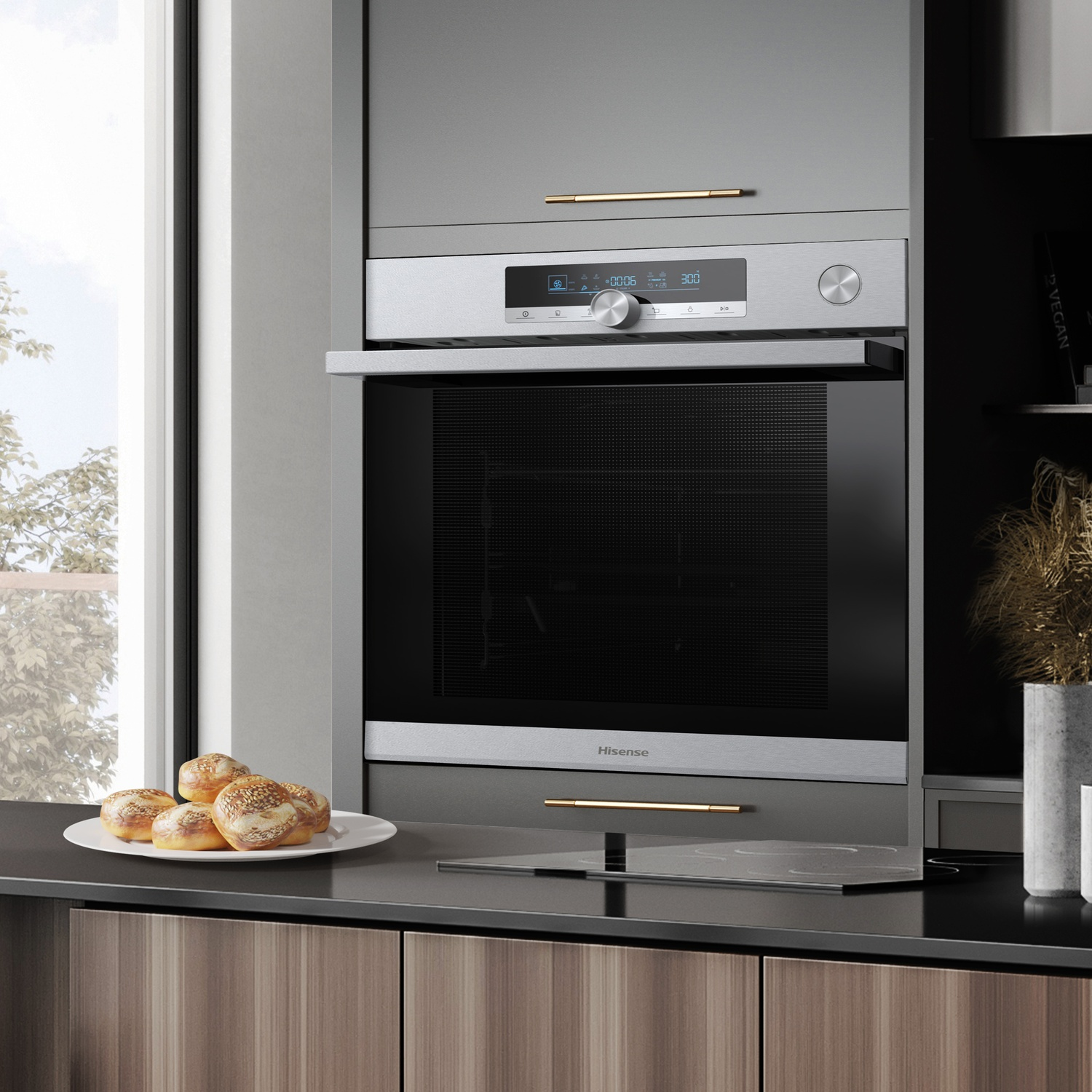 Scena di cucina con forno Hisense. Piatto di panini sul bancone. Mobile in legno, una finestra con vista esterna.