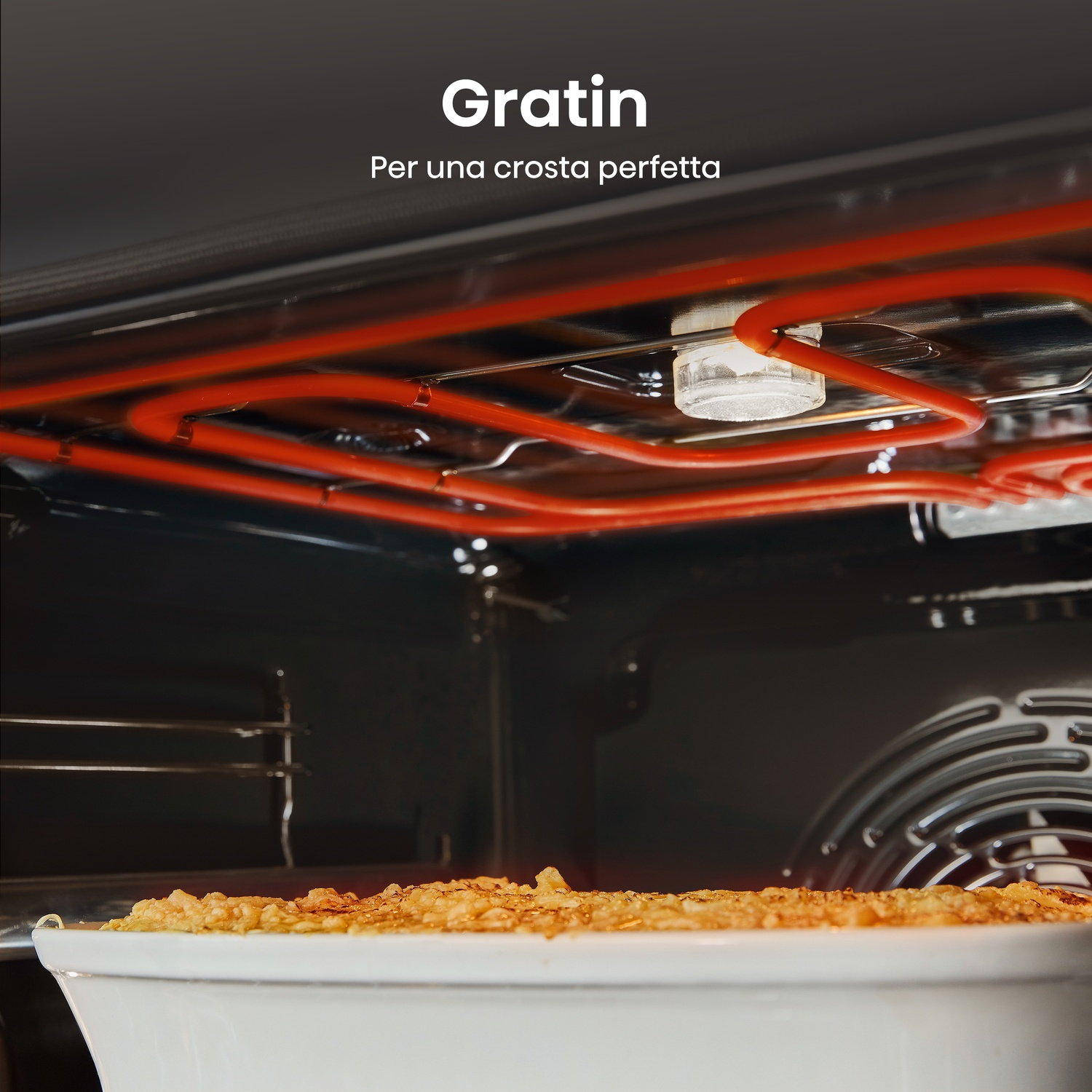 Interno forno con teglia gratinata. Elementi riscaldanti rossi. La teglia sotto, piena di piatto dorato.