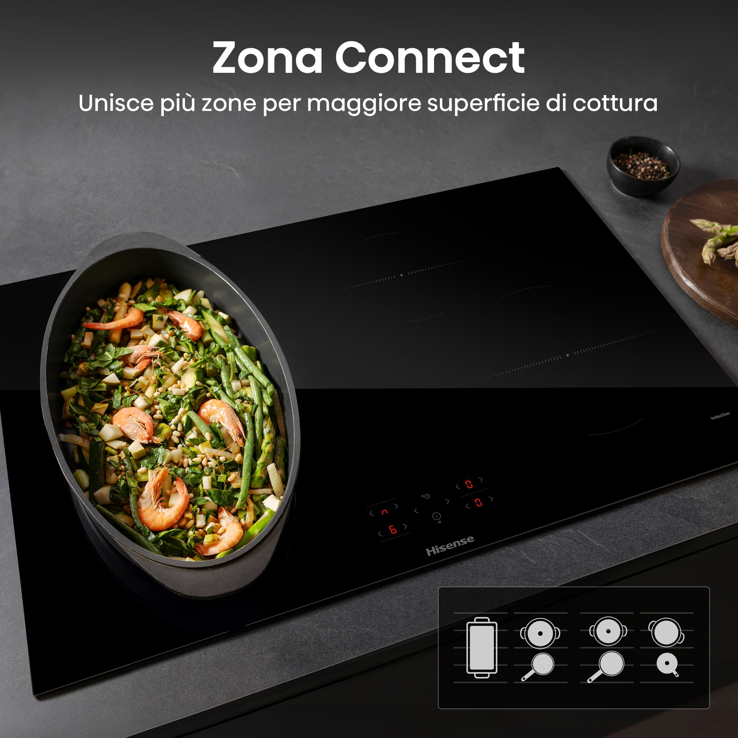 Piano cottura a induzione nero con una padella di gamberi e verdure. Include testo, una ciotola di spezie e un tagliere di legno con asparagi.