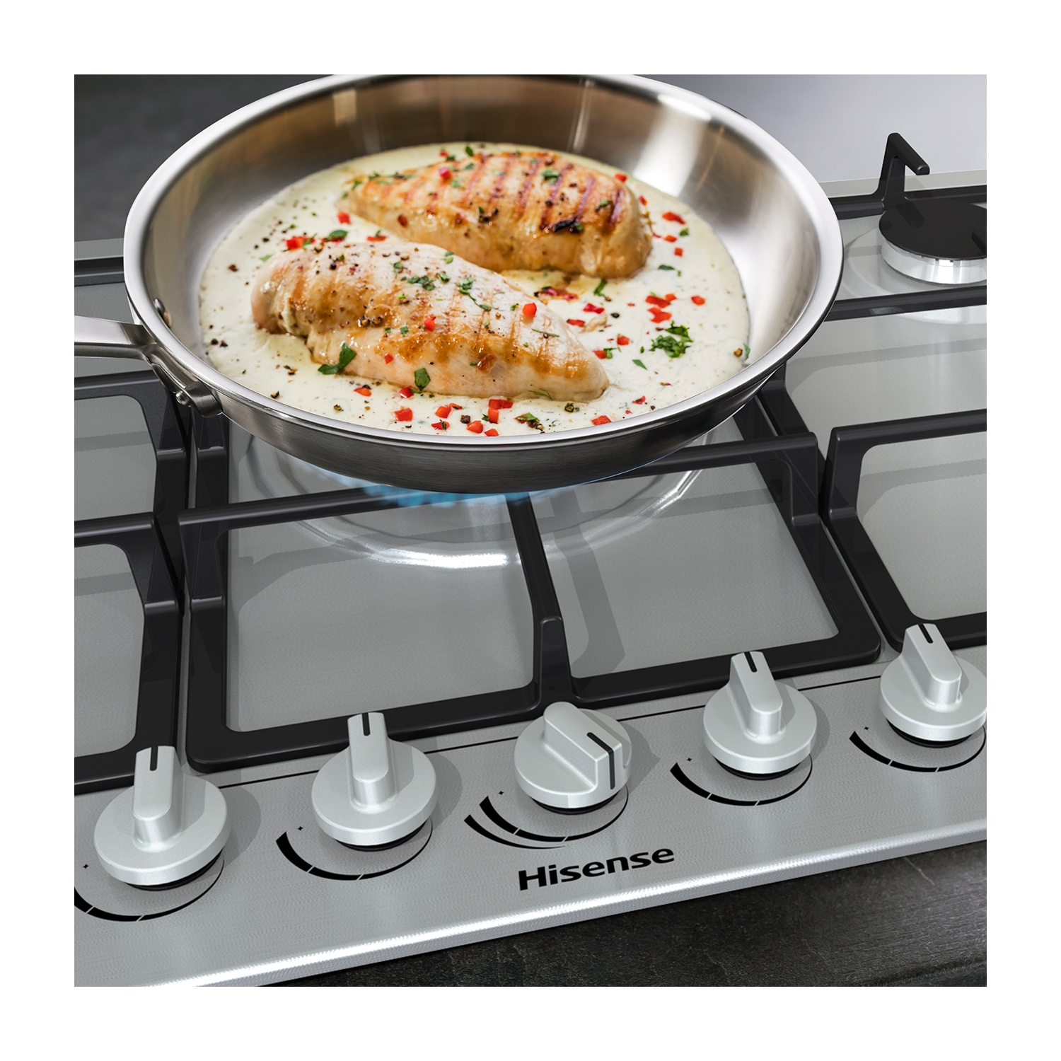 Due petti di pollo cotti in padella con salsa su un fornello. Il fornello ha manopole argentate. Hisense è visibile.