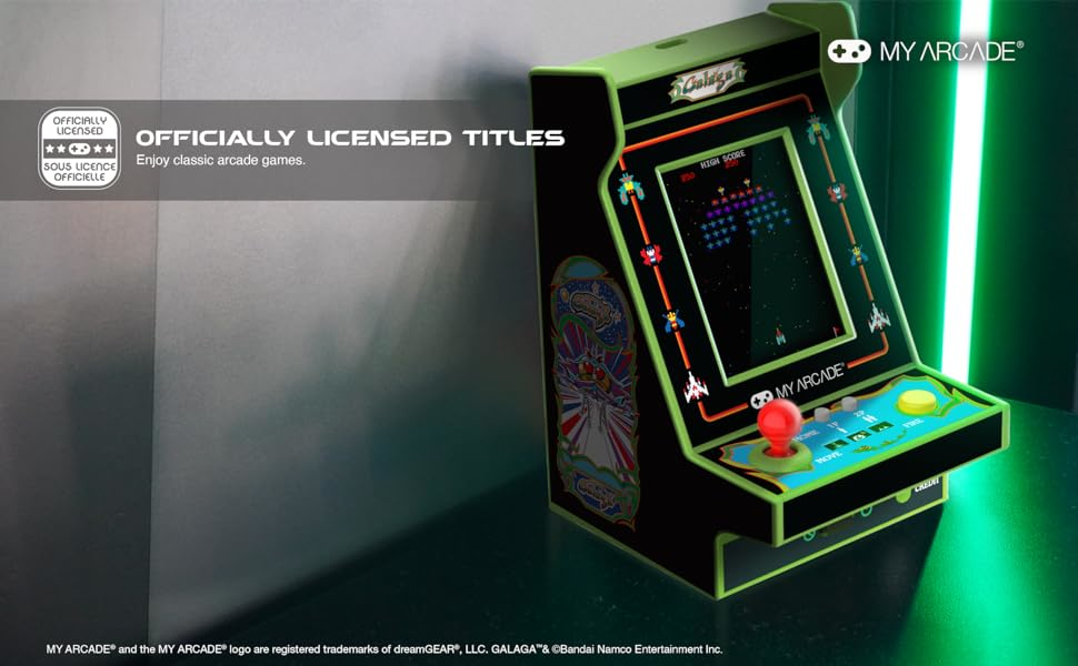 Une borne d'arcade avec un jeu Galaga. La machine est noire et verte. L'arrière-plan est un dégradé.