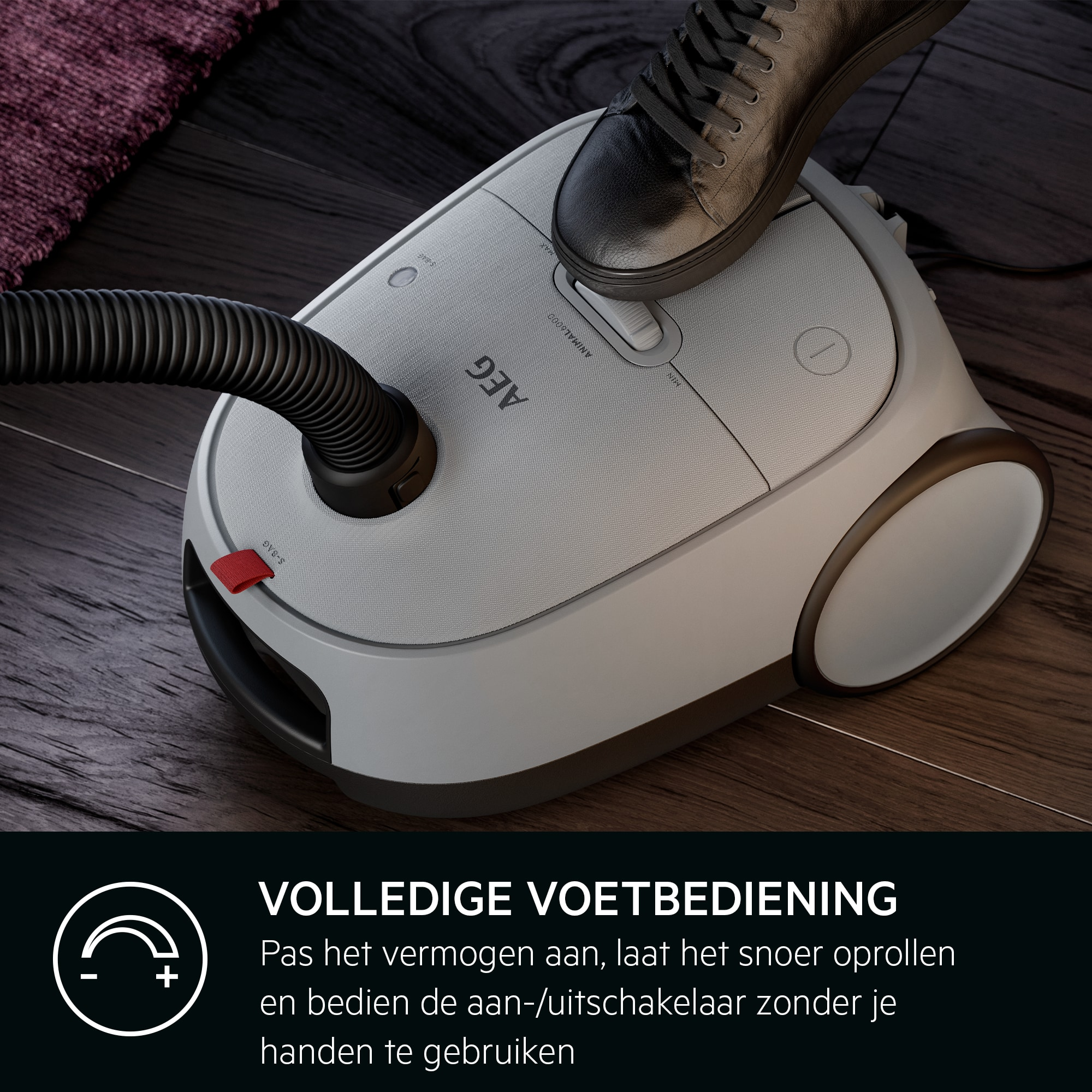 Un pied marche sur un aspirateur gris clair. Le sol est en bois. Un tapis est en arrière-plan. Le texte dit 'Full Foot Control'.