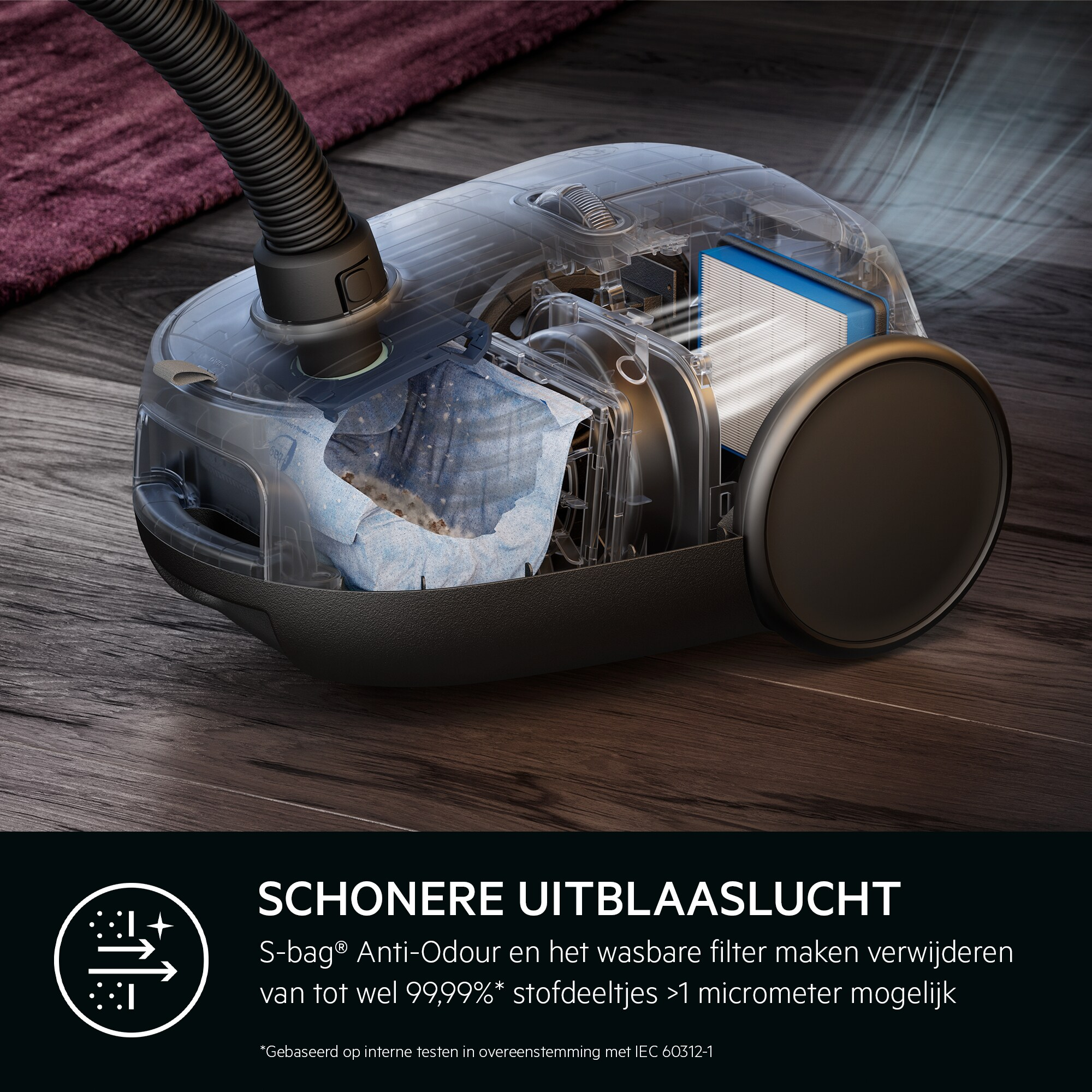 Aspirateur transparent montrant les composants internes. Un filtre, un sac et un tuyau sont visibles, avec un fond de plancher en bois.