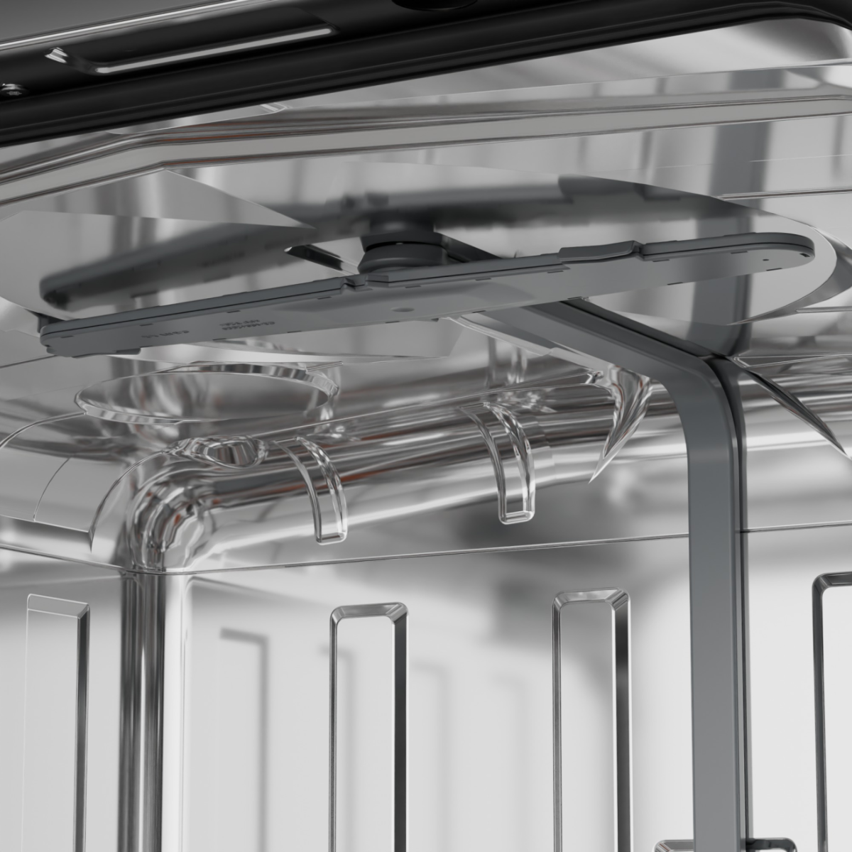 Innenseite eines Geschirrspülers. Silberner, metallischer Innenraum mit Sprüharmen und Gestellen. Klare Kunststoffwasserrohre. Reflektierende Oberflächen.