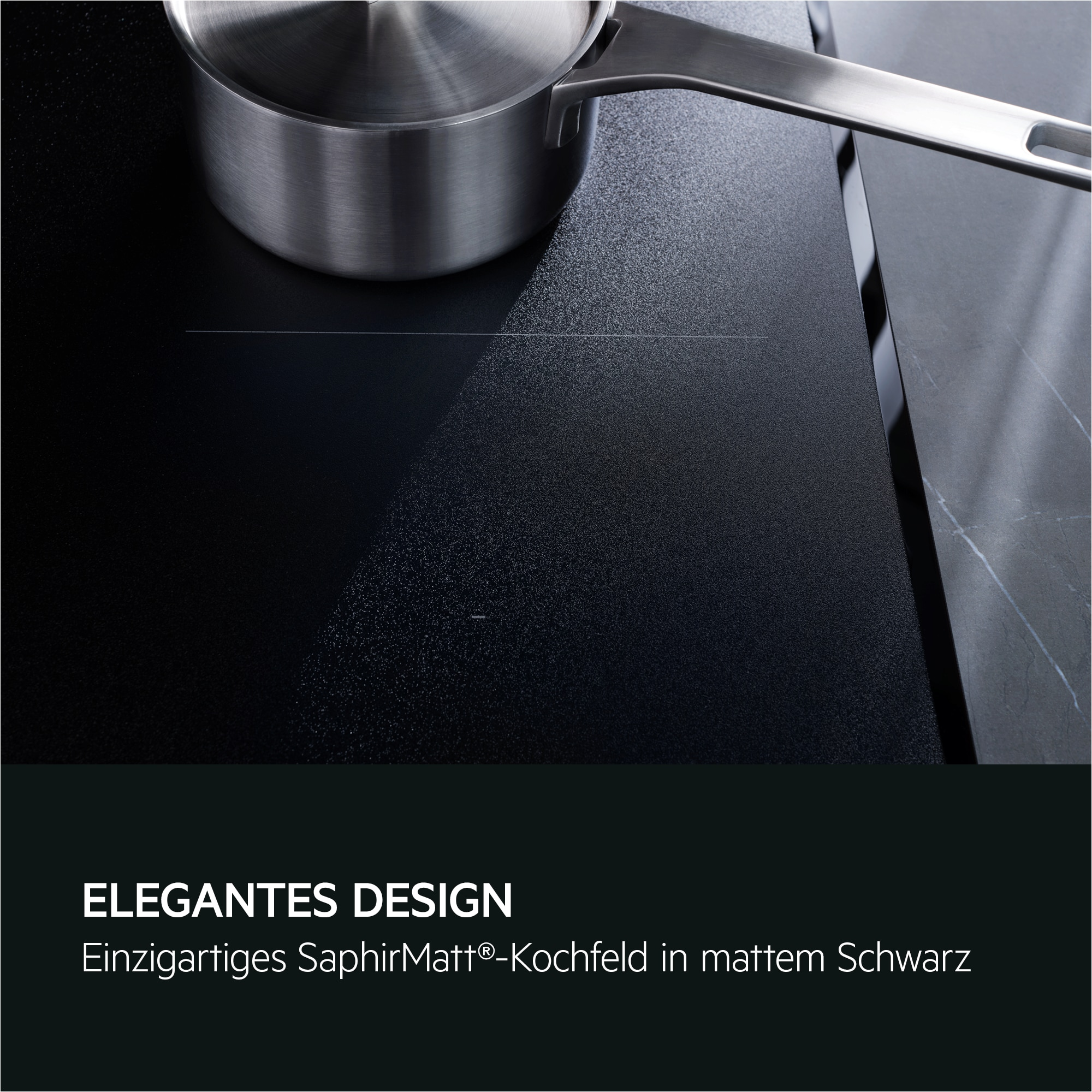 Ein Edelstahltopf steht auf einem mattschwarzen Kochfeld. Das Kochfeld hat ein schlankes Design mit dunkler Marmoroptik.