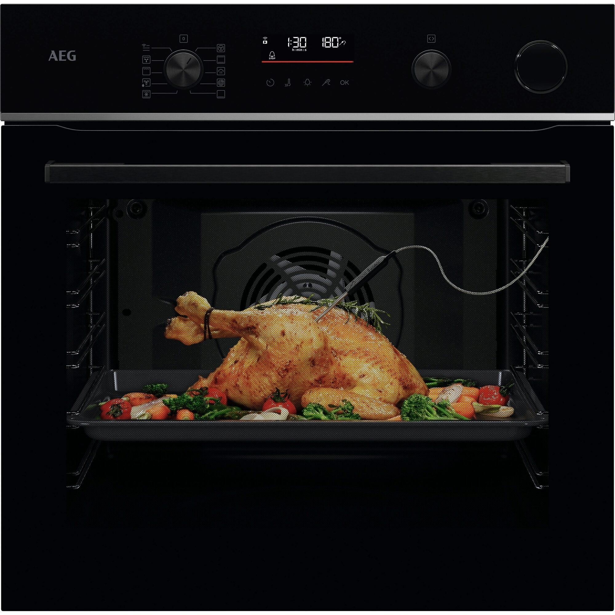 Ein Ofen mit gebratenem Huhn und Gemüse. Der Ofen ist schwarz. Das Display zeigt Zeit und Temperatur.