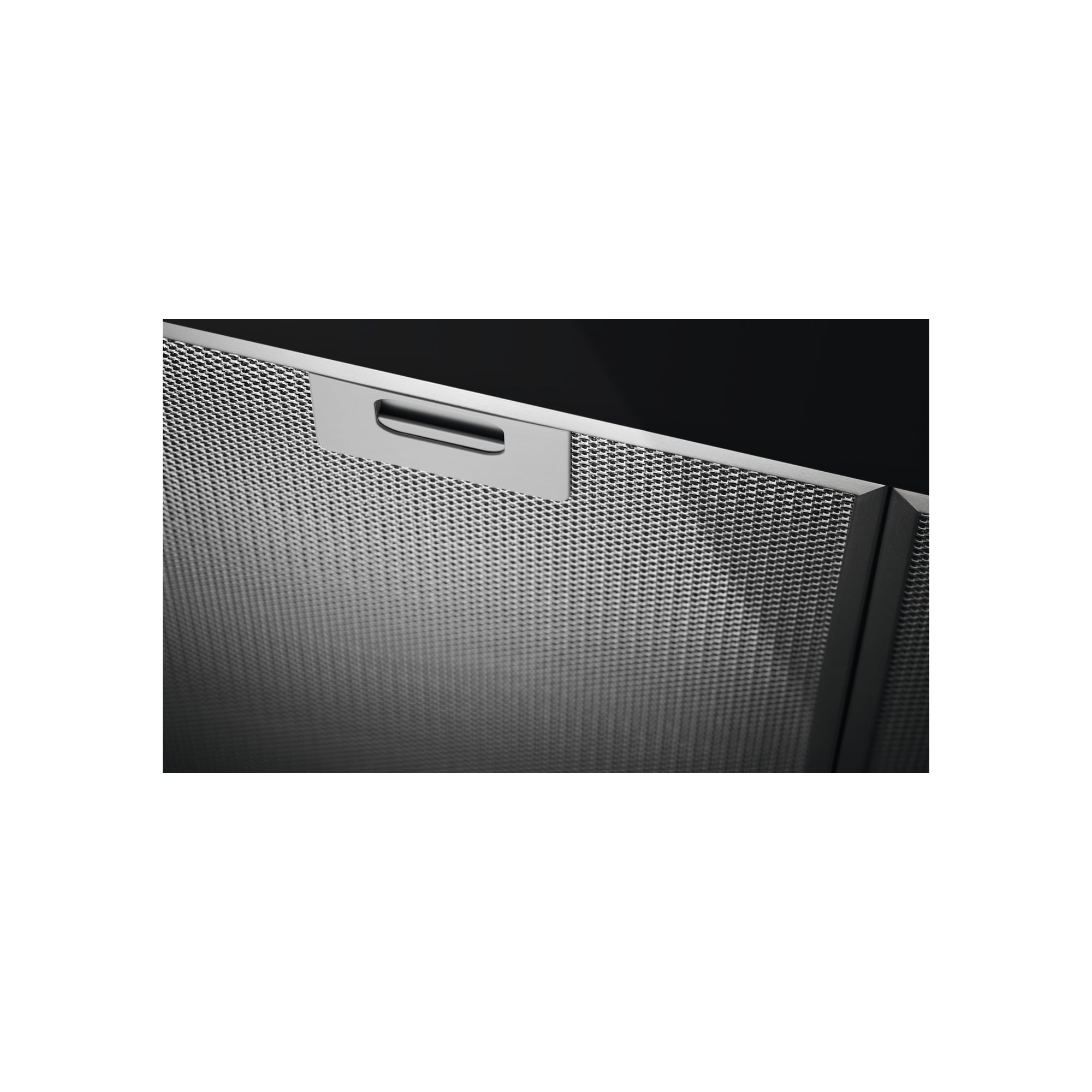 Zbliżenie metalowego filtra okapu z uchwytem. Ma perforowaną powierzchnię i czarne tło.