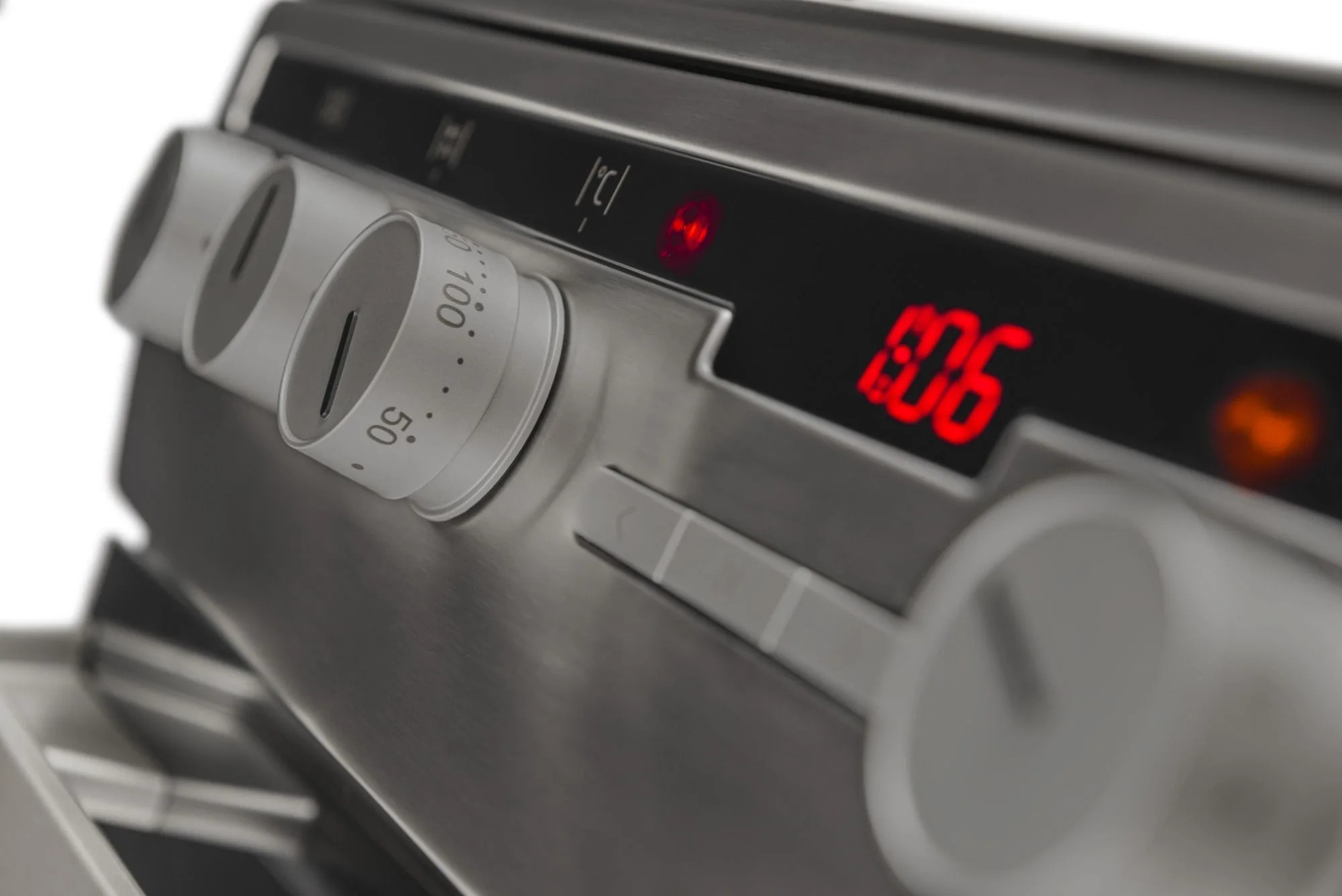 Zbliżenie panelu sterowania piekarnika. Pokrętła, wyświetlacz cyfrowy pokazujący temperaturę i czas. Dominują kolory srebrny i czarny.