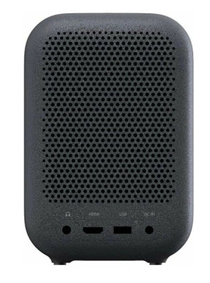 Ciemnoszary głośnik z perforowanym przodem. Dół ma porty HDMI, USB, zasilania i gniazdo słuchawkowe. Małe nóżki.