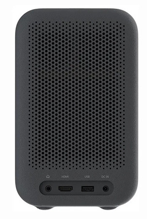 Ciemnoszary głośnik z perforowanym przodem. Na dole porty: słuchawki, HDMI, USB i DC IN. Zaokrąglone rogi.