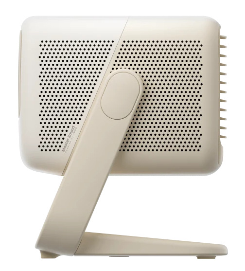 Kremowy głośnik ze stojakiem. Głośnik ma perforowany przód. Stojak jest ustawiony pod kątem i podtrzymuje głośnik.