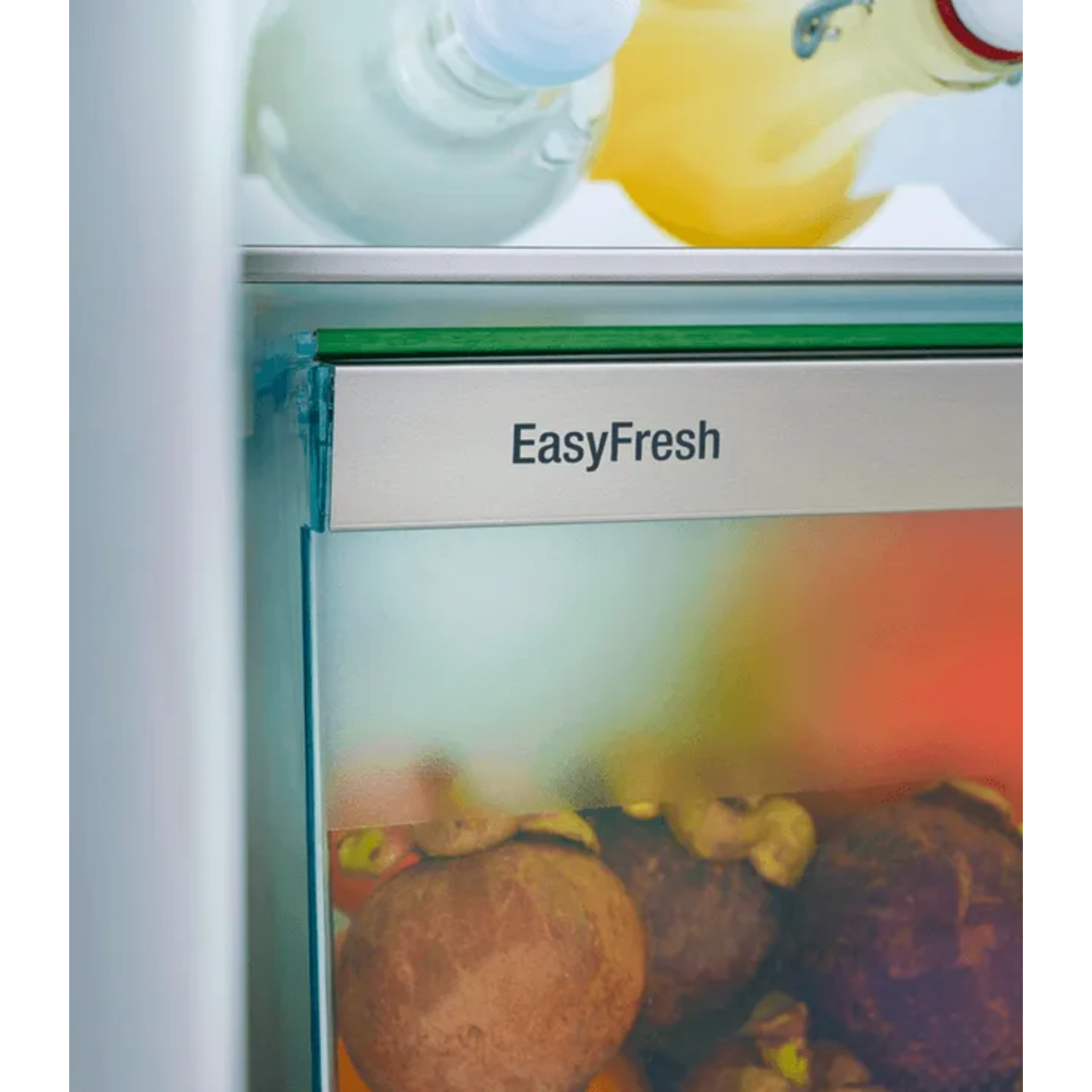 Refrigerator interior with EasyFresh label. Bottles and fruits are visible, including mangosteens.