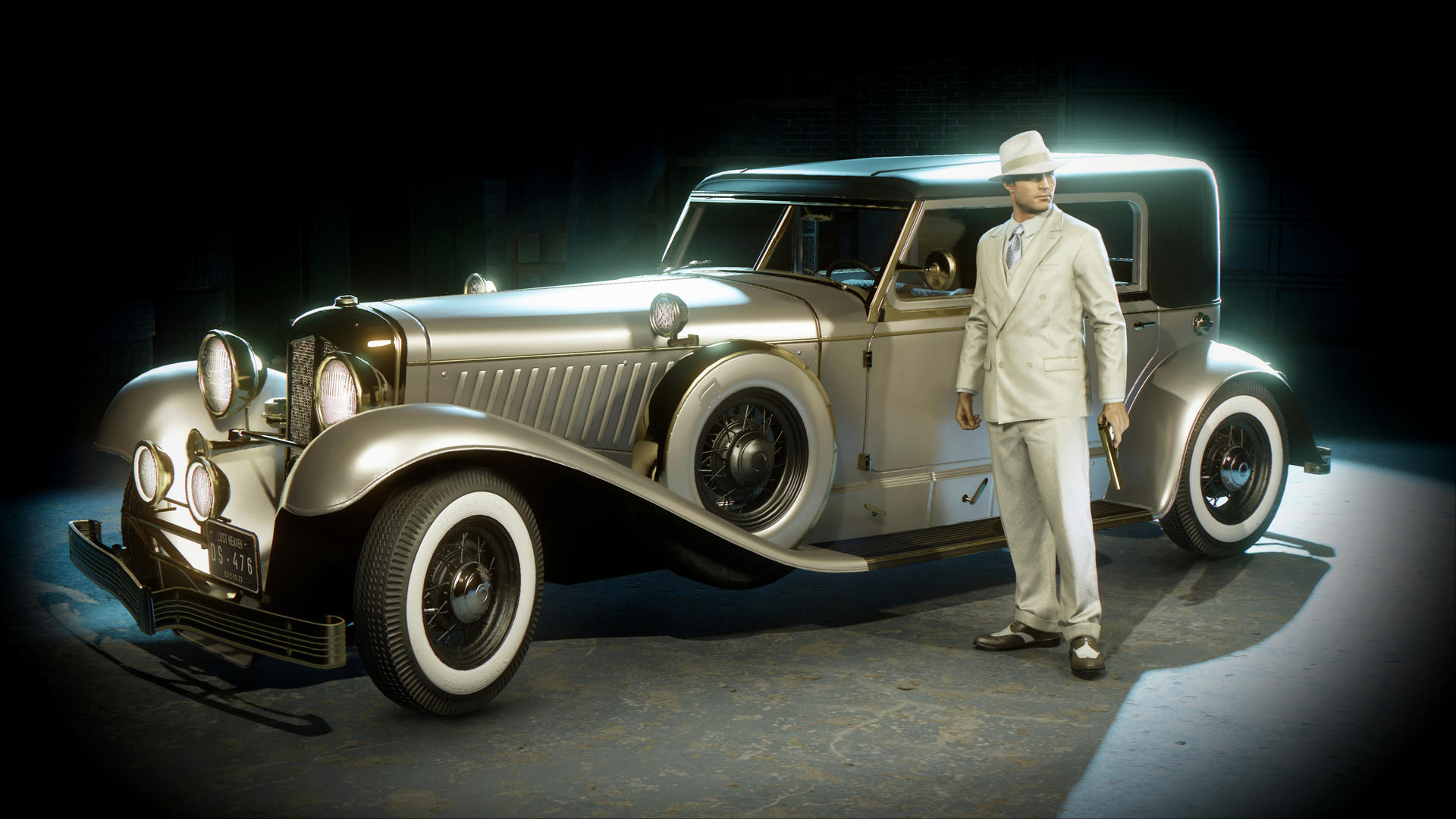 Mężczyzna w białym garniturze stoi obok zabytkowego samochodu. Ma kapelusz i trzyma pistolet. Samochód jest srebrny i czarny.