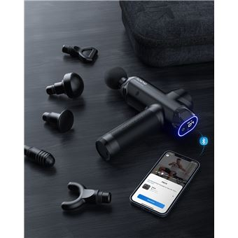 Pistola de masaje negra con accesorios, teléfono que muestra la aplicación, sobre superficie oscura. Icono de Bluetooth visible.
