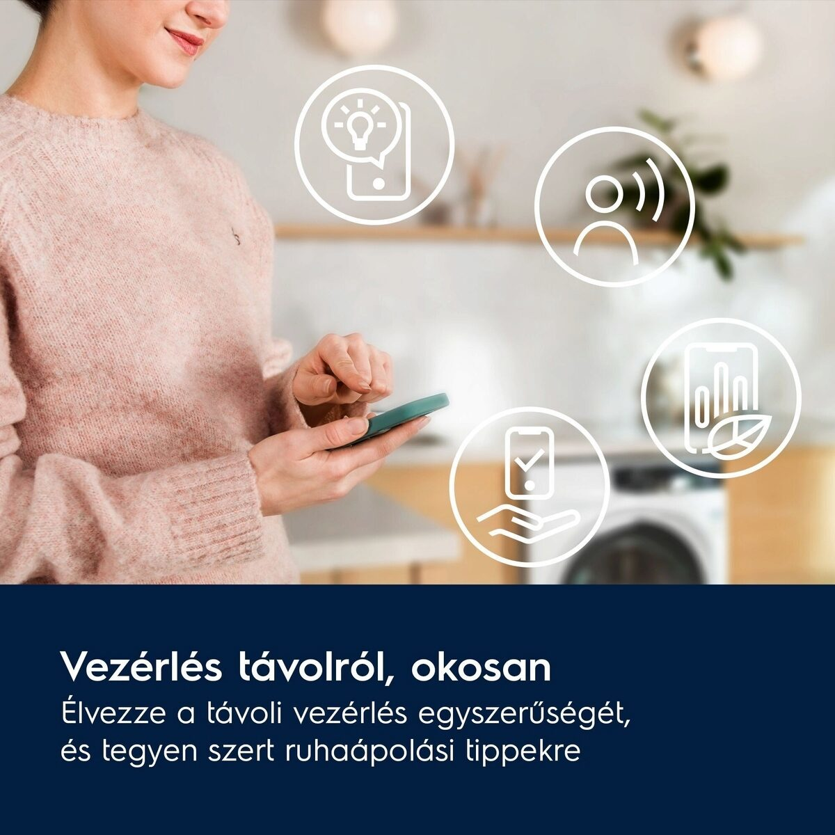 Egy nő okostelefont használ okosotthon ikonokkal. Rózsa színű pulóvert visel. A háttérben egy mosógép látható.