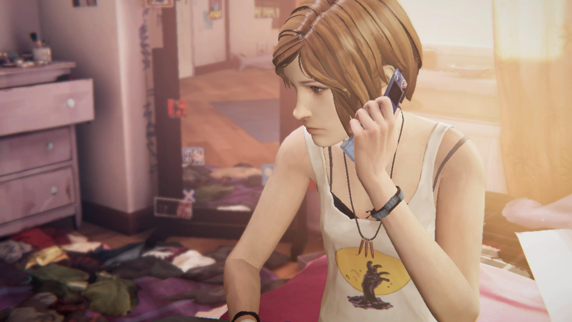 Ein Mädchen telefoniert drinnen, bekleidet mit einem Tanktop. Kleidung liegt auf dem Boden verstreut. Eine Kommode und ein Fenster sind sichtbar.