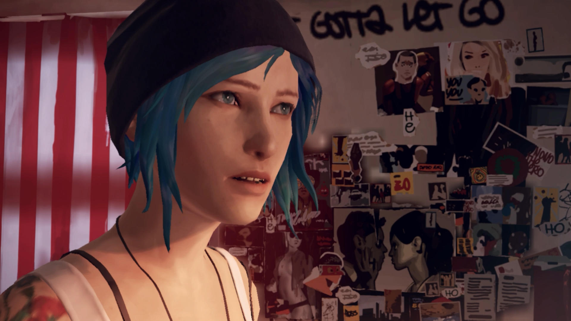 Eine Frau mit blauen Haaren und einer schwarzen Mütze wirkt leicht besorgt. Poster und Graffiti bedecken eine Wand im Hintergrund.