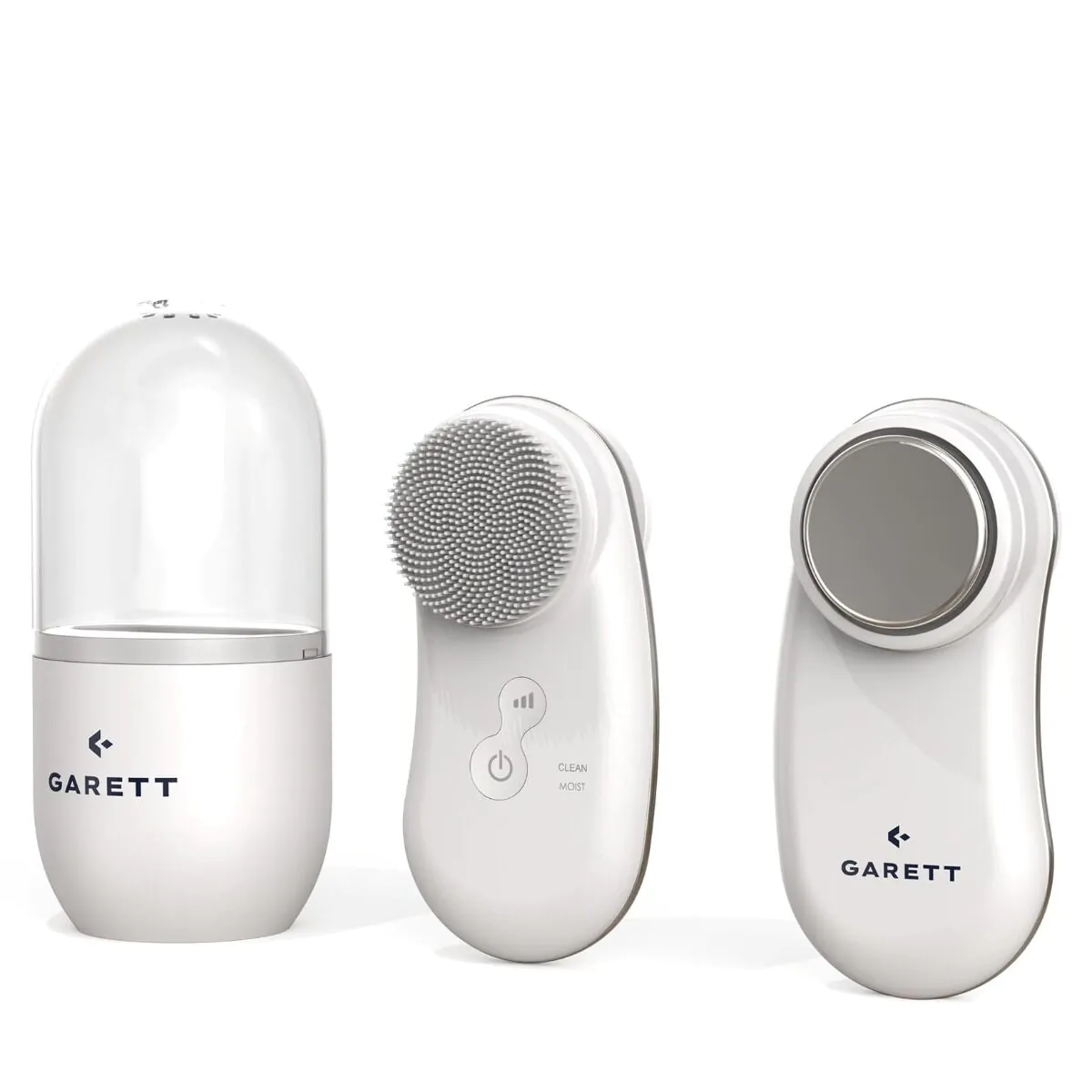 Trzy białe urządzenia do pielęgnacji skóry Garett: stacja ładująca z przezroczystą osłoną, szczoteczka do czyszczenia i masażer do twarzy.