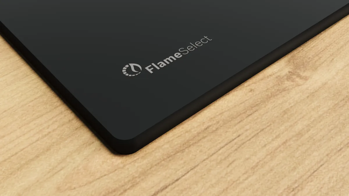 FlameSelect logolu siyah yüzey. Arka plan ahşap dokusu. Siyah yüzeyin köşesi görünür.