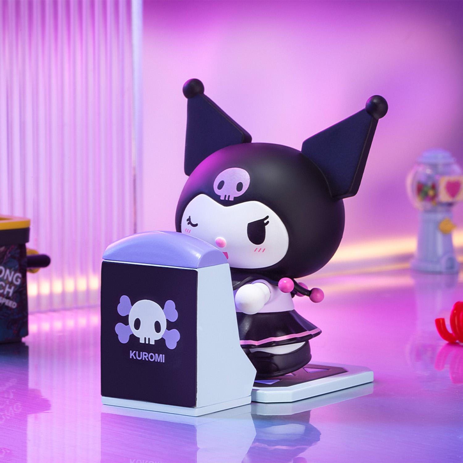 Eine Kuromi-Figur steht neben einer schwarz-weißen Box mit einem Totenkopf-Logo. Der Hintergrund ist lila mit einem Kaugummiautomaten.