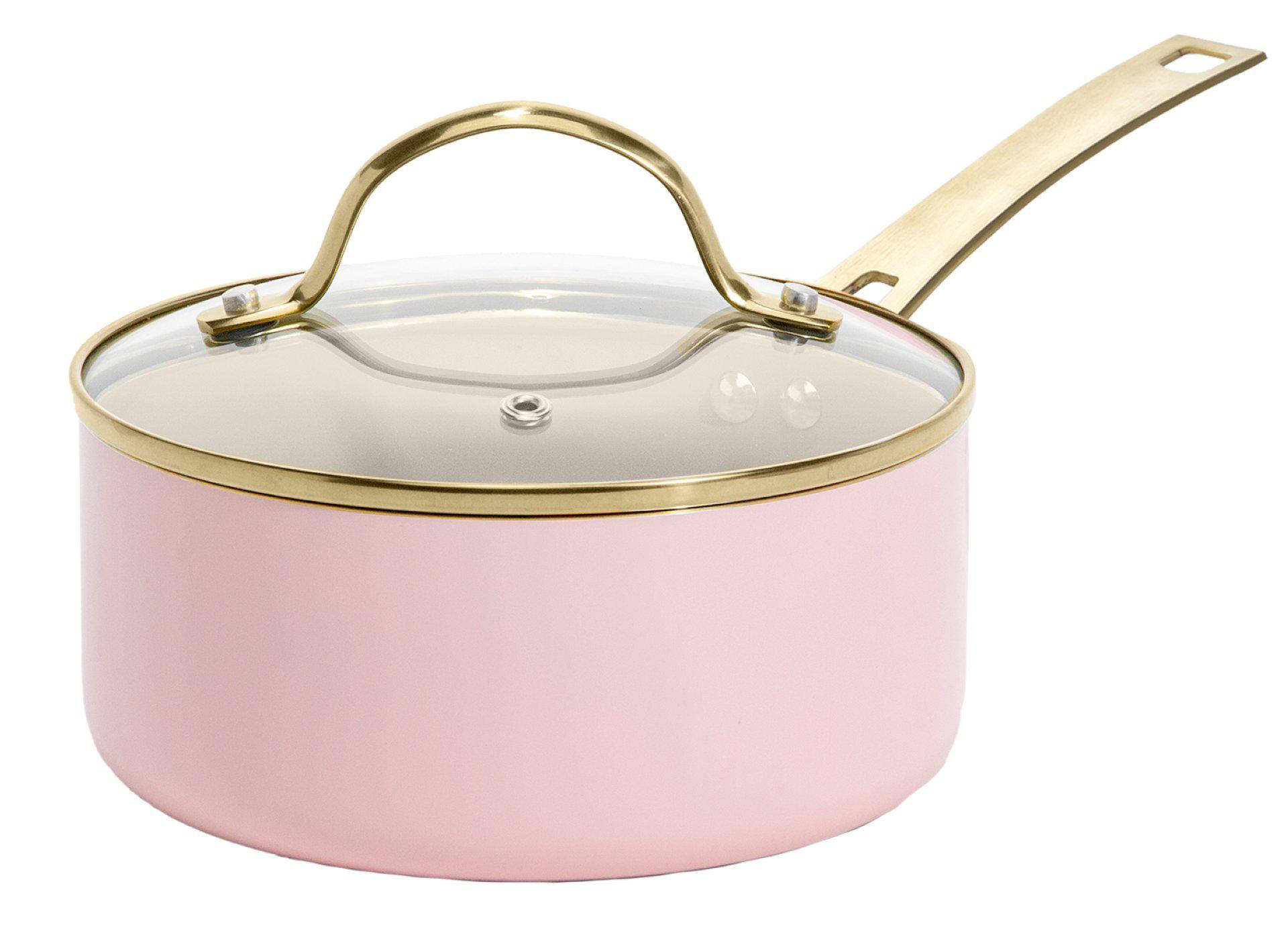 Ein rosa Kochtopf mit Glasdeckel und goldenem Griff und Rand. Es befindet sich auf weißem Hintergrund.