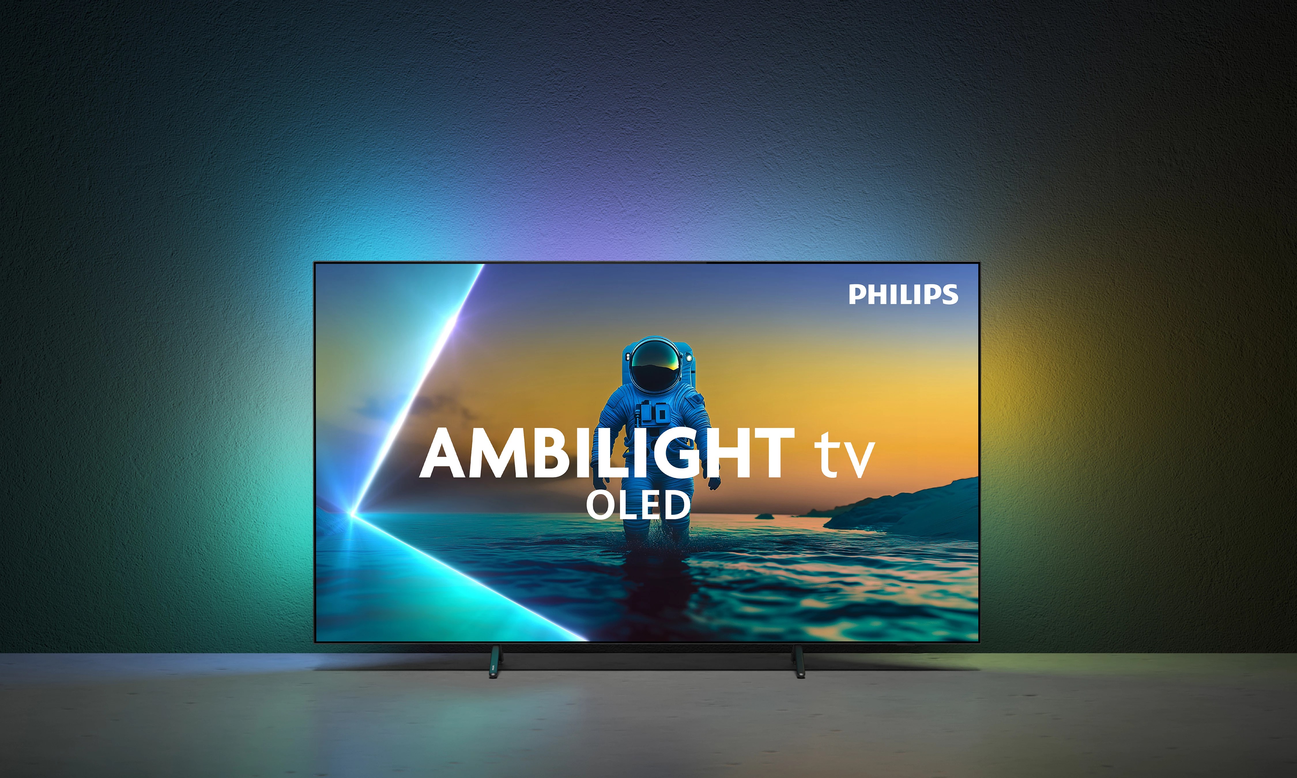 Ein Philips Ambilight OLED-Fernseher zeigt einen Astronauten am Strand bei Sonnenuntergang. Der Fernseher steht vor einer farbverlaufenden Wand.