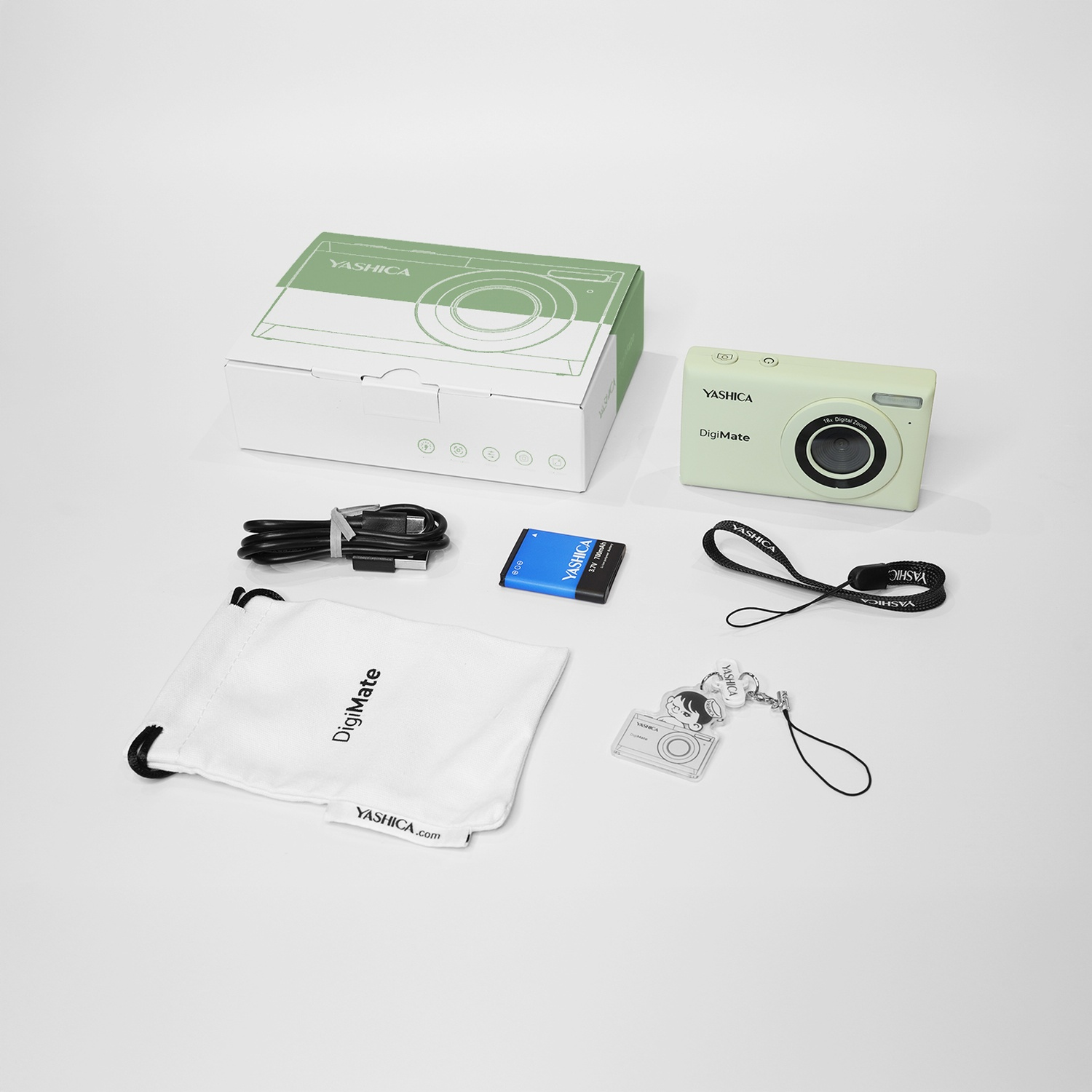 Un kit fotocamera Yashica Digimate verde chiaro con accessori. Include scatola, cavi, batteria, borsa, cinturino e portachiavi.