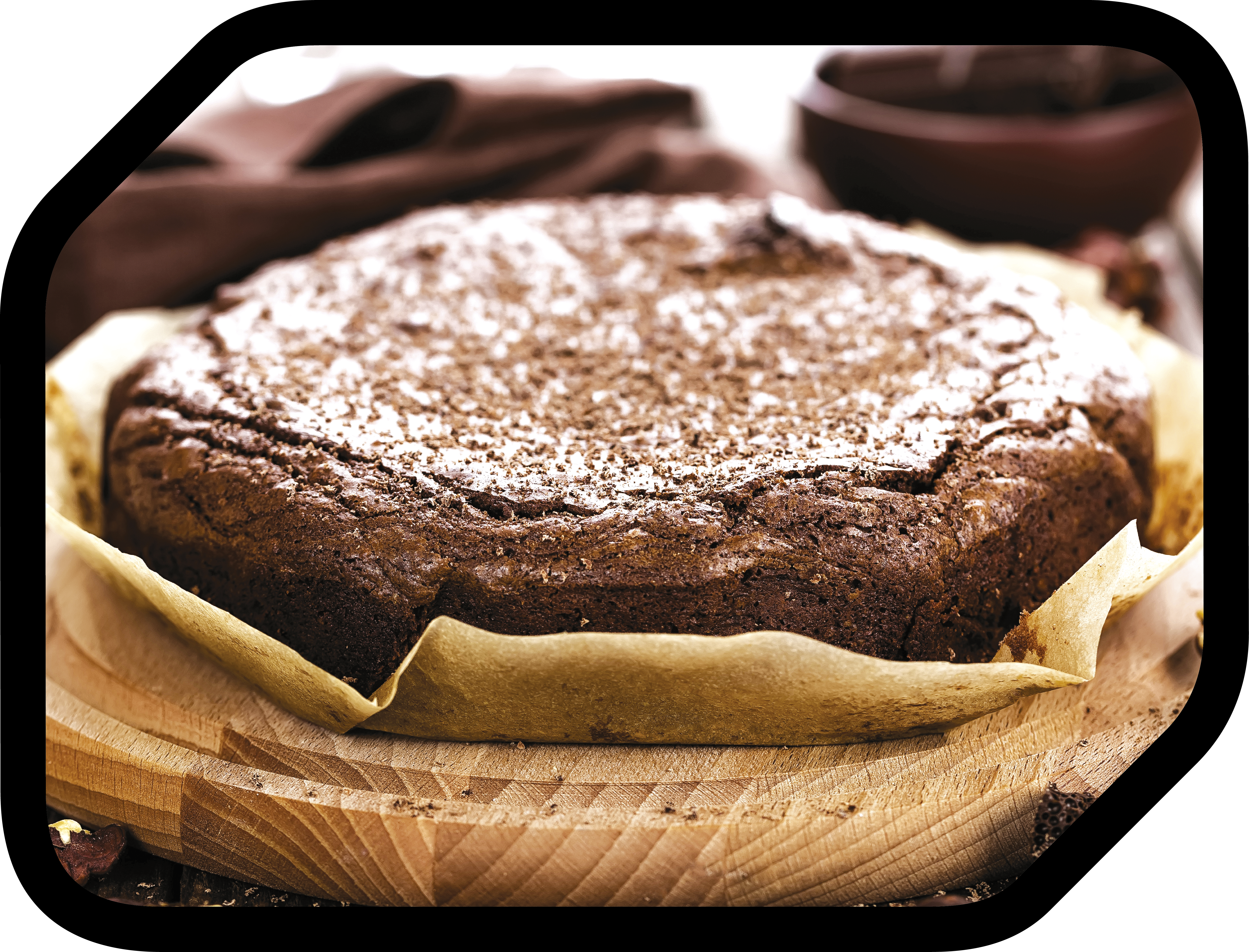 Ein Schokoladenkuchen mit Puderzucker auf einem Holzbrett, im Hintergrund ein braunes Tuch.