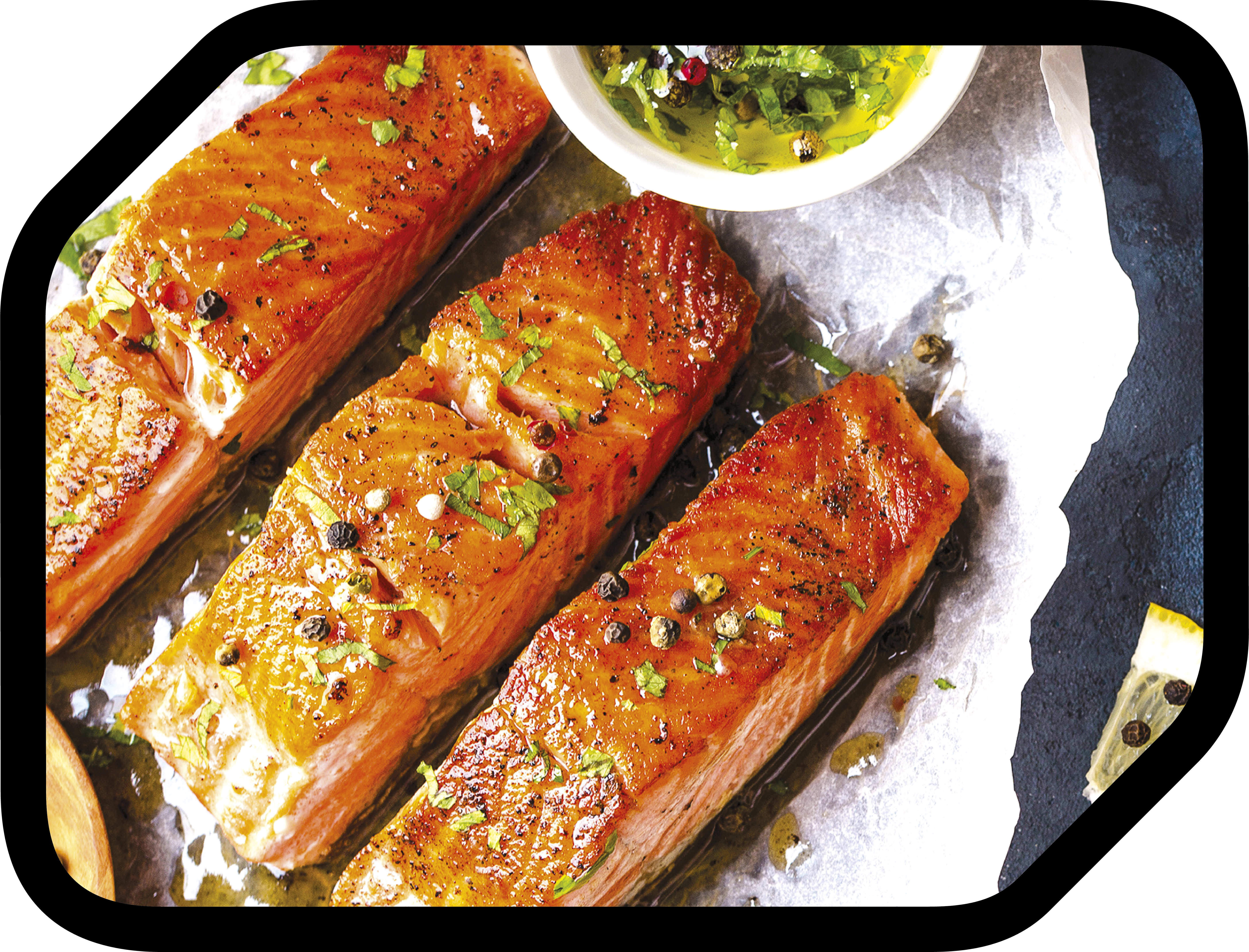 Gegrillte Lachsfilets mit Kräutern und Pfefferkörnern, serviert mit einer Kräutersauce, auf weißem Papier und dunklem Hintergrund.