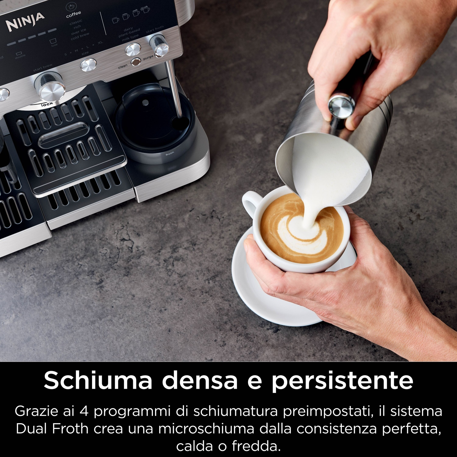 Una persona versa il latte in una tazza di caffè con latte art, vicino a una macchina per caffè Ninja. La macchina per caffè è argento e nera.