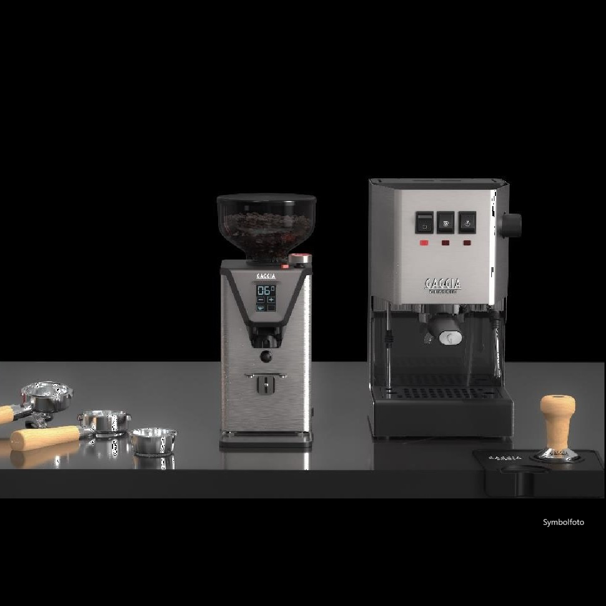 Silbernes Espressomaschinen- und Mahlwerk-Set auf schwarzer Oberfläche. Zubehör umfasst einen Tamper und Siebträger.