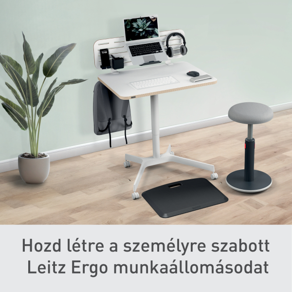 Modern munkahelyi beállítás laptop, fejhallgató és kiegészítőkkel egy fehér asztalon. Szürke szék és növény a háttérben.