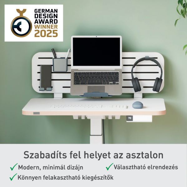 Fehér asztal laptop, fejhallgató és kiegészítőkkel. German Design Award Winner 2025 logó. Zöld fal háttér.