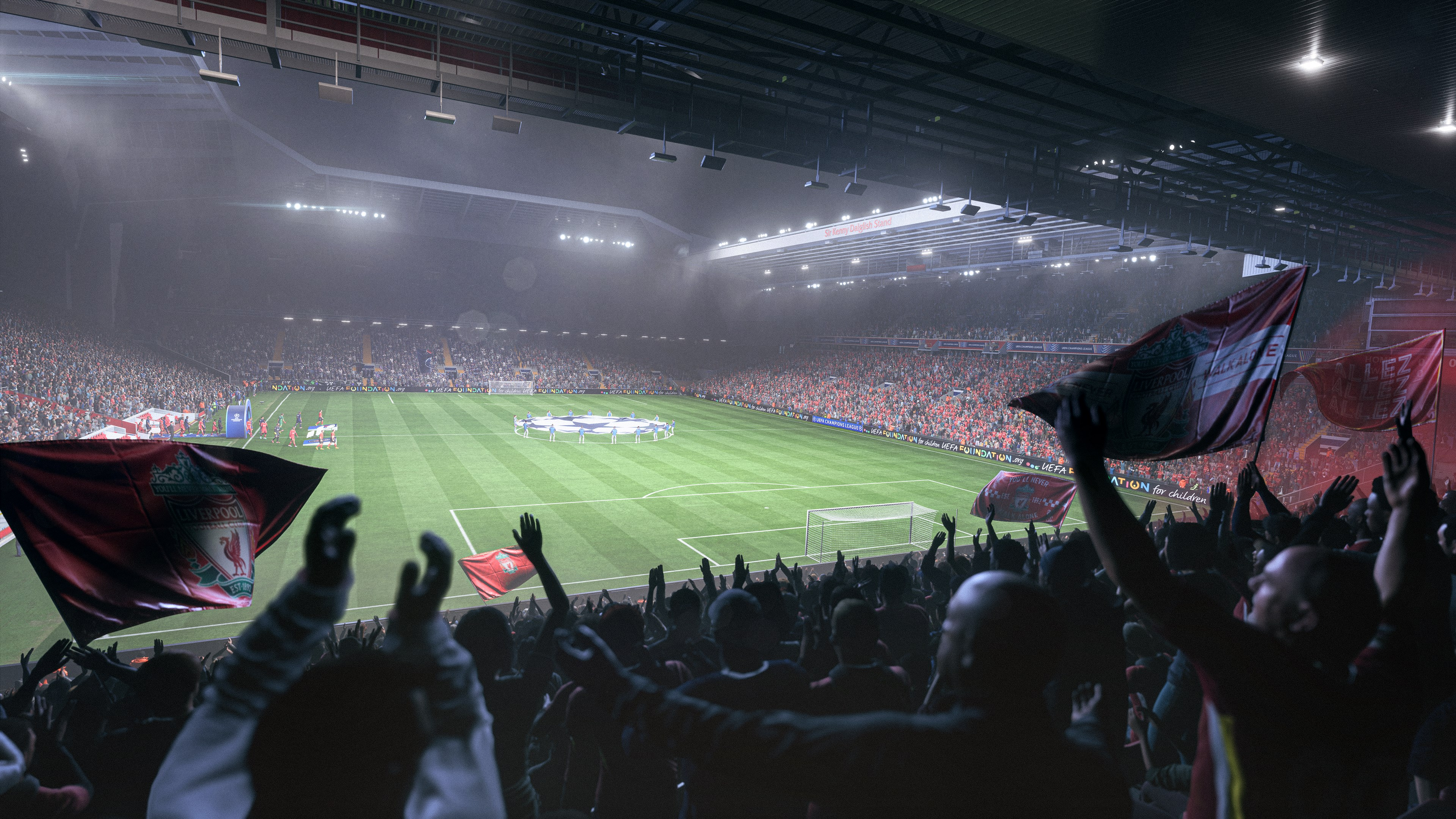 Un stade de football rempli de fans en liesse agitant des drapeaux rouges. Le terrain est vert et le ciel nuageux.