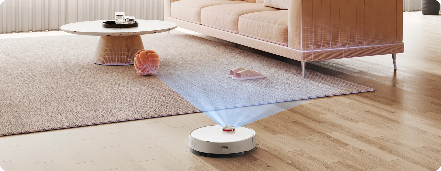 Egy robotporszívó takarít egy nappalit. Egy szőnyeg, kanapé és dohányzóasztal mellett van.