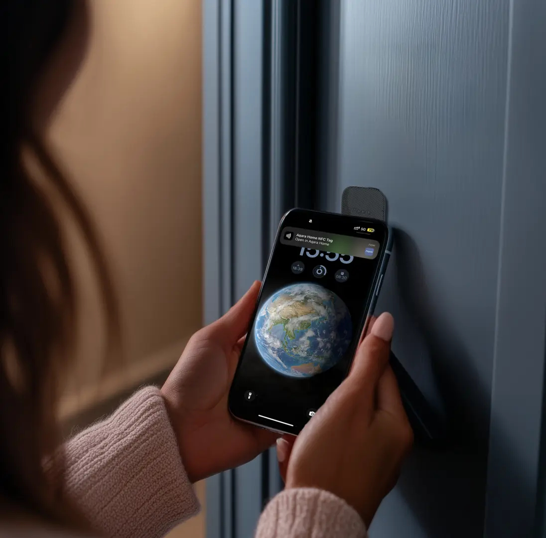 Eine Person hält ein Telefon mit Erde-Hintergrundbild und entriegelt eine Tür. Rechts ist eine Tür, und das Telefon zeigt ein Aqara NFC-Tag.