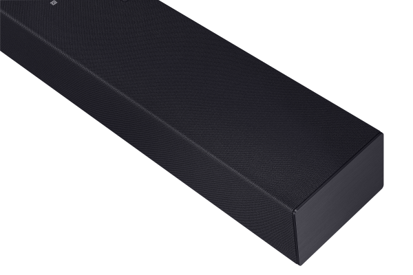 Dokulu yüzeye sahip, koyu renkli bir soundbar'ın yakın çekimi. Arka plan siyah, ürünün şeklini ve detaylarını vurguluyor.