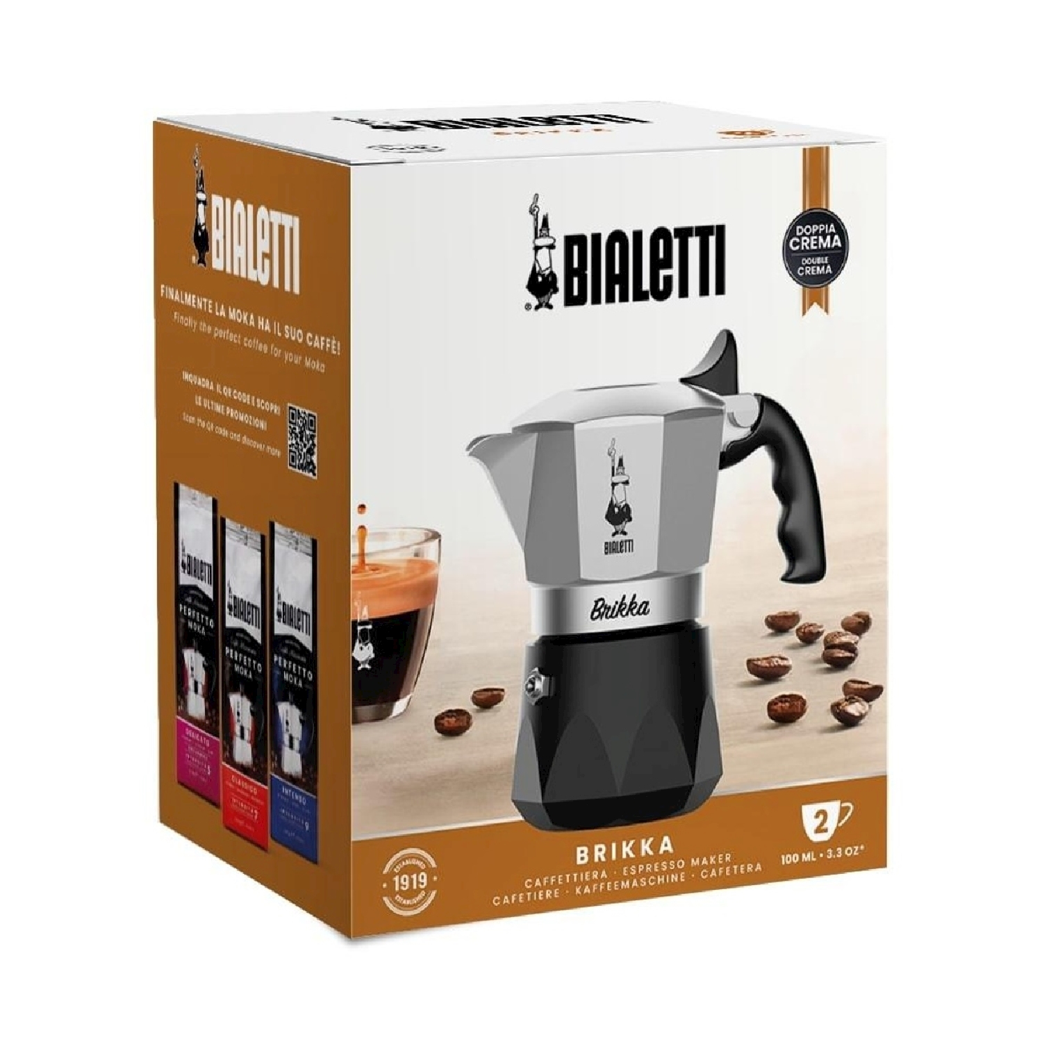 Scatola della caffettiera espresso Bialetti Brikka con chicchi di caffè, un bicchiere di caffè e sacchetti di caffè. La scatola è bianca e marrone.