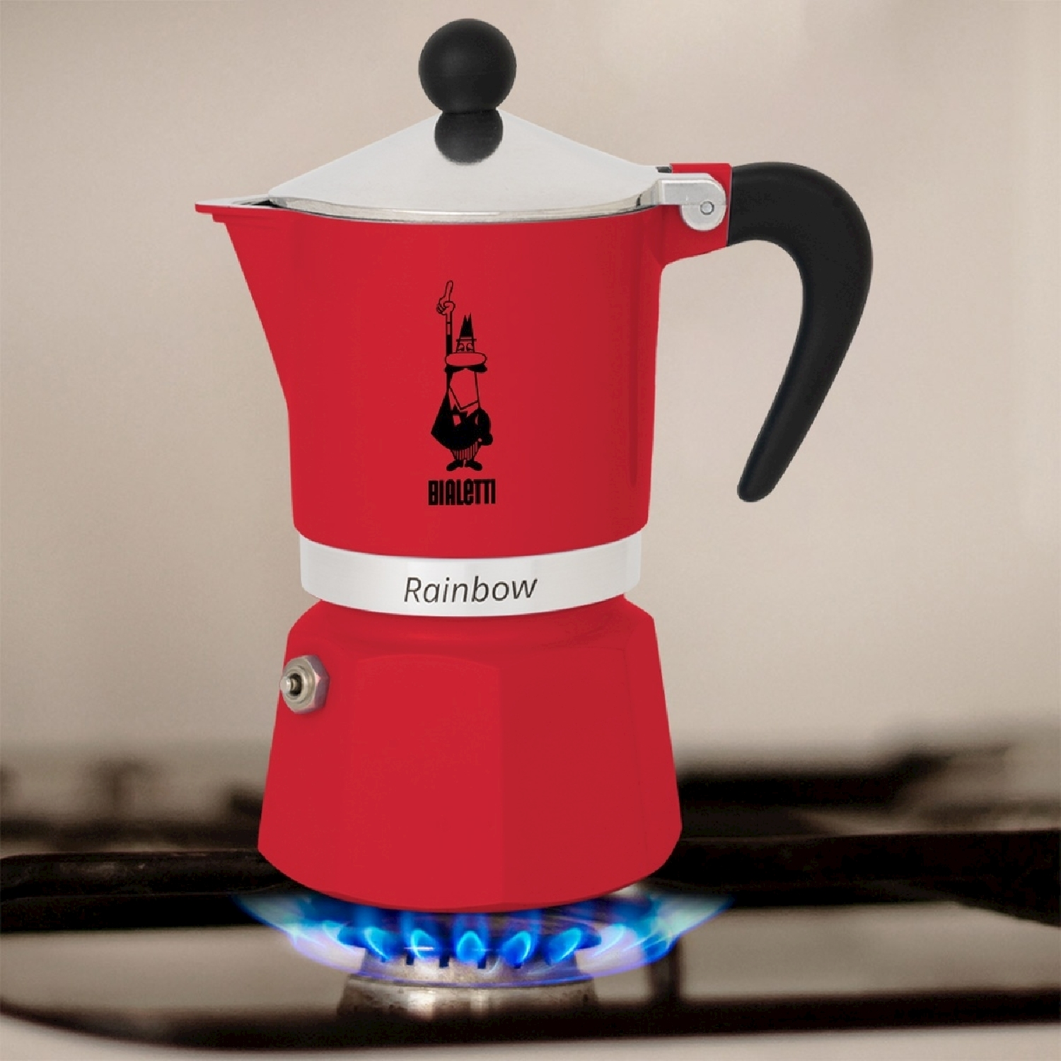 Una caffettiera espresso Bialetti Rainbow rossa su un fornello a gas con fiamme blu. La caffettiera ha un manico nero e un coperchio argentato.