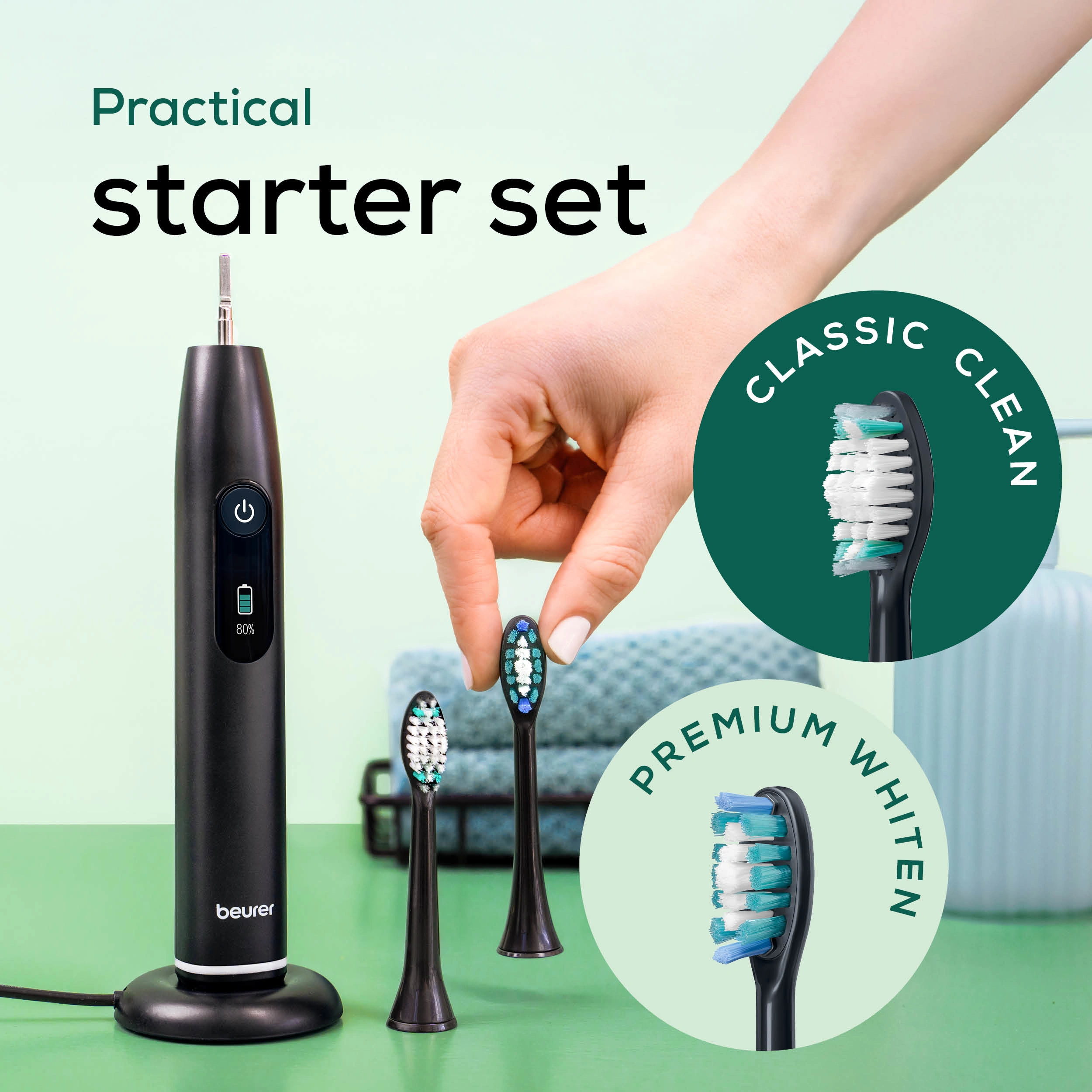Schwarze elektrische Zahnbürste mit drei Bürstenköpfen. Hand hält einen. Grüner Hintergrund, Text: Praktisches Starter-Set.