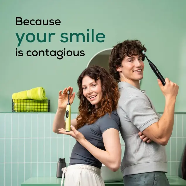 Une femme et un homme sourient, tenant des brosses à dents. Le texte indique : Parce que votre sourire est contagieux.