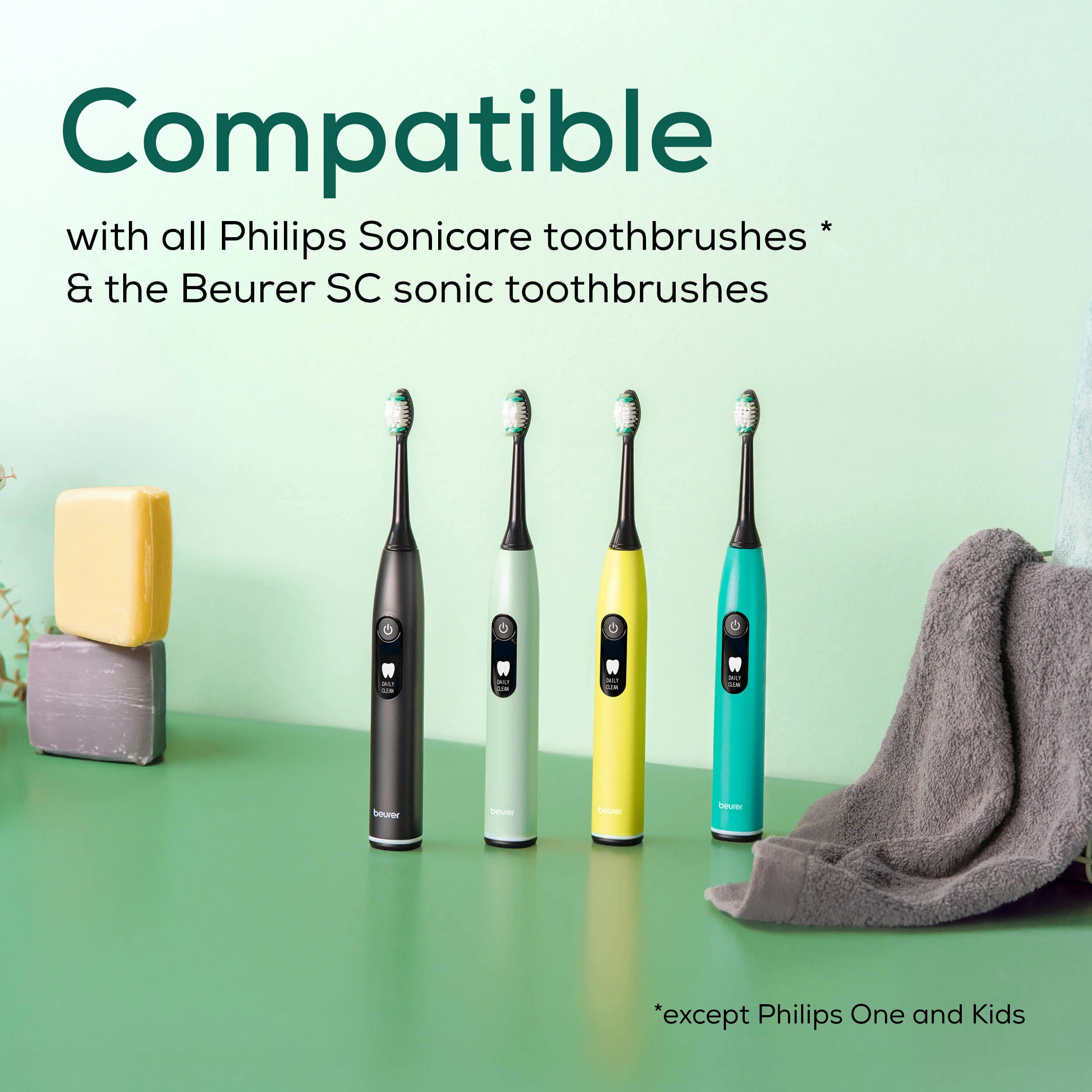Quatre brosses à dents électriques colorées se dressent. Savon et serviette sont sur le côté. Le texte en haut dit compatible avec les brosses à dents.