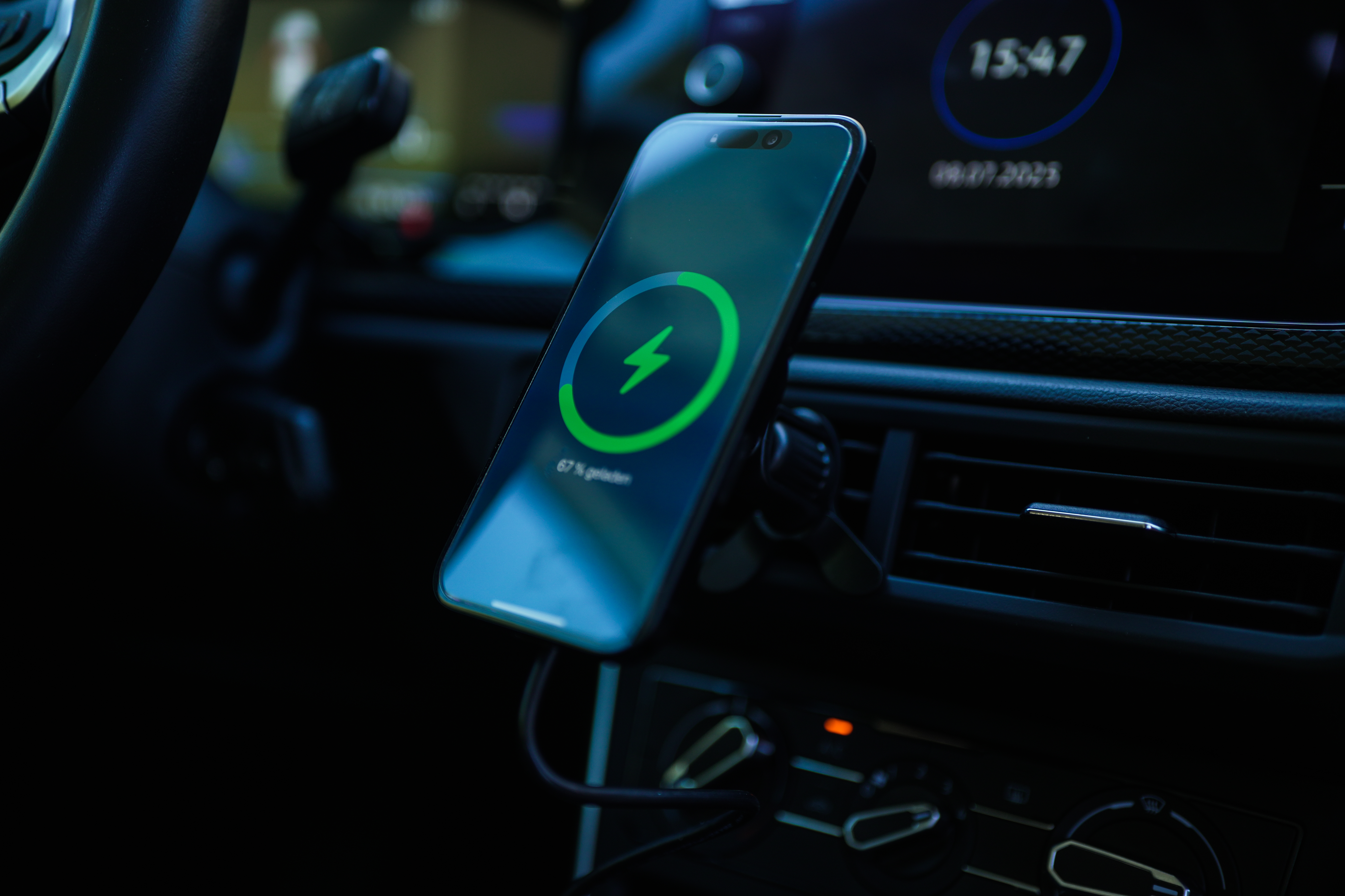Ein Telefon ist in einem Auto montiert. Es zeigt ein Ladesymbol. Die Uhrzeit ist 15:47. Das Datum ist 08.07.2023.