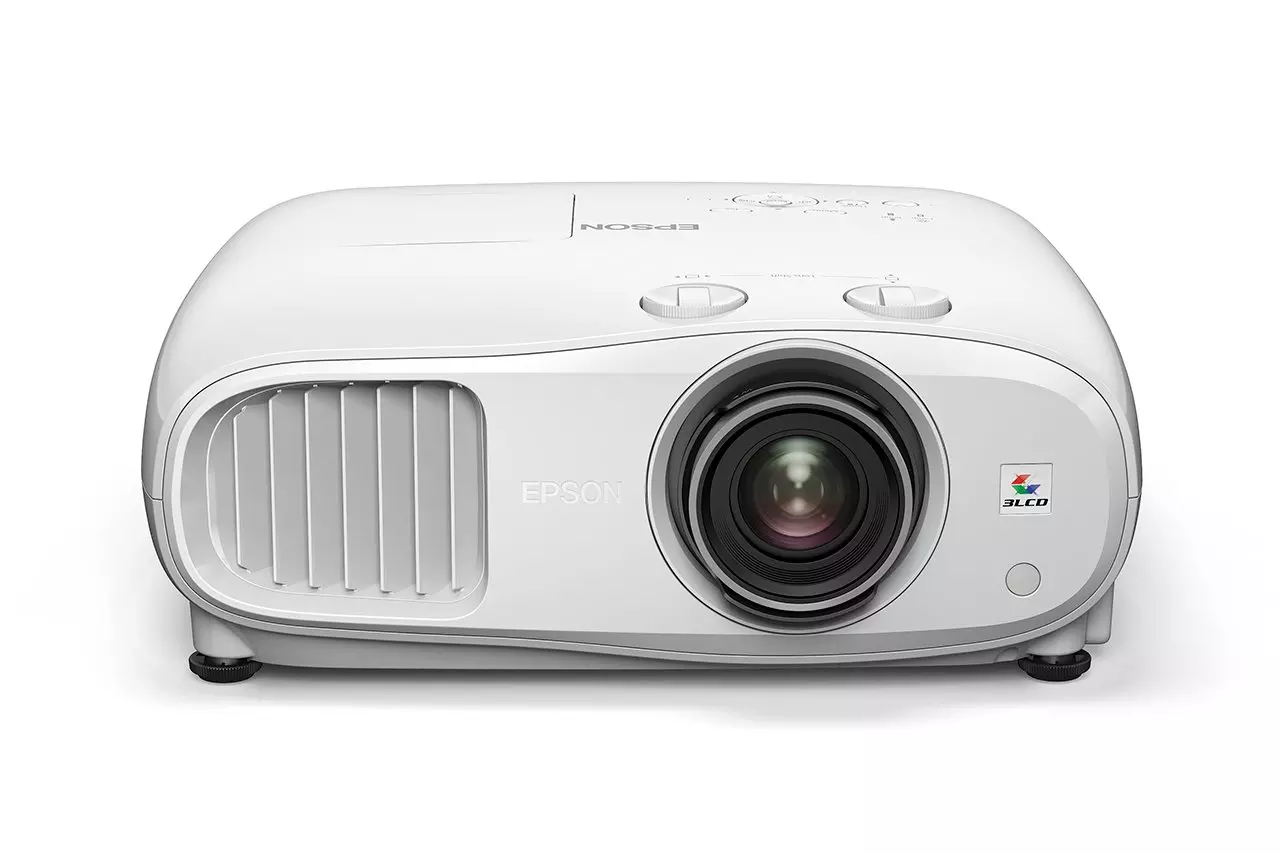 Egy fehér Epson projektor. Az elején lencse, szellőzőnyílás és vezérlőgombok találhatók. Az Epson logó látható.