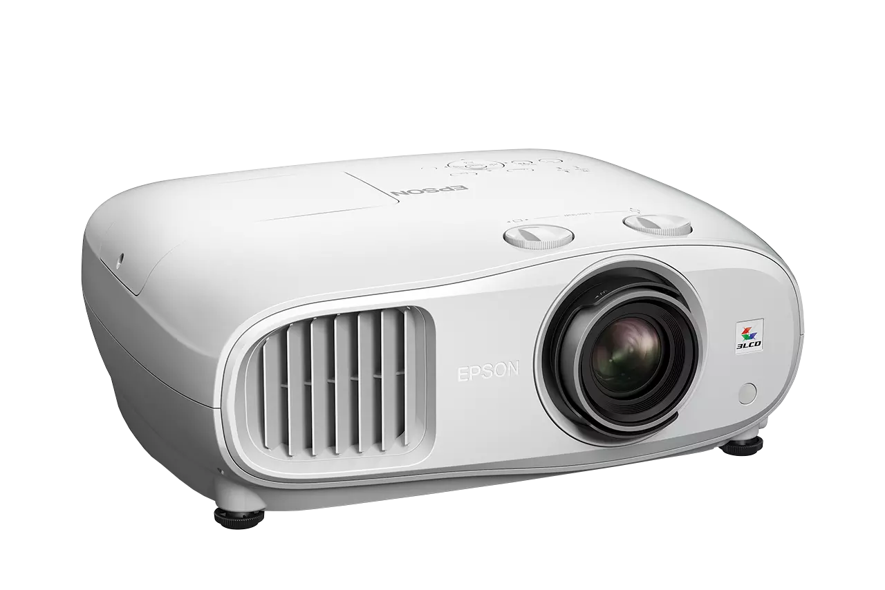 Fehér Epson projektor fekete háttérben. Lencséje, szellőzőnyílásai és vezérlőgombjai vannak. Látható az Epson logó.