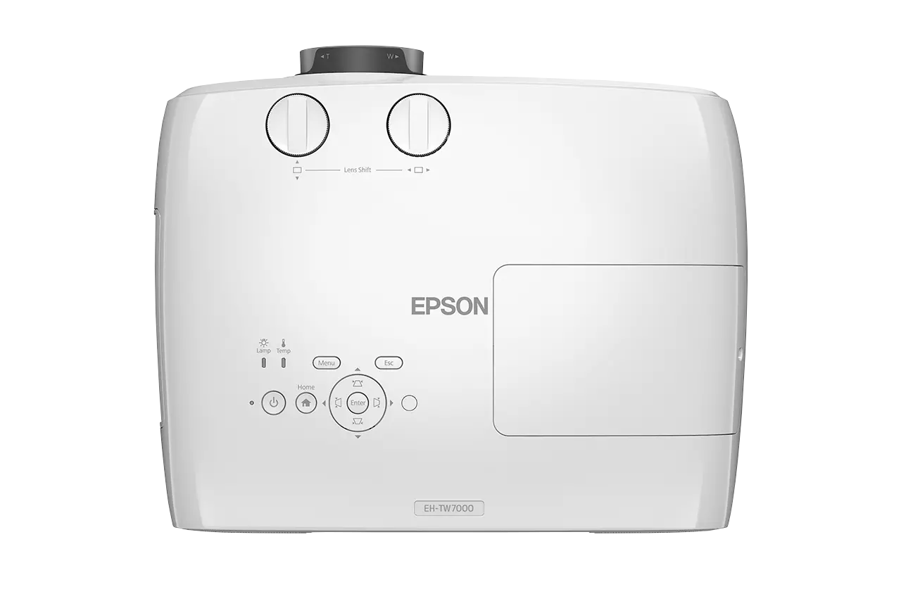 Egy fehér Epson EH-TW7000 projektor. Lencsebeállító gombokkal és menü, home és bekapcsoló gombokkal rendelkezik. Az Epson logója látható.