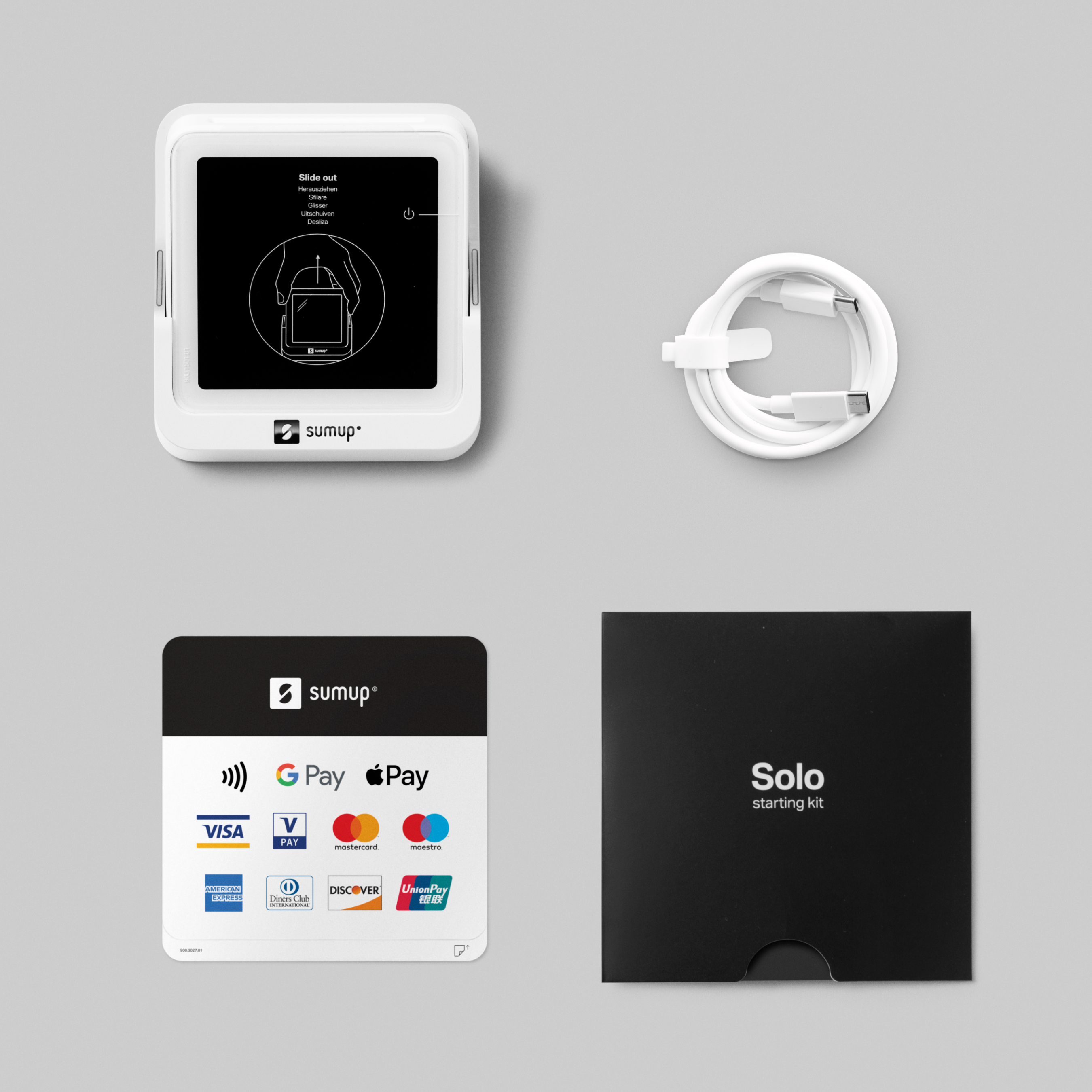 Ein weißes SumUp Solo-Gerät, Kabel, Zahlungsterminal und eine schwarze Box auf grauem Hintergrund.