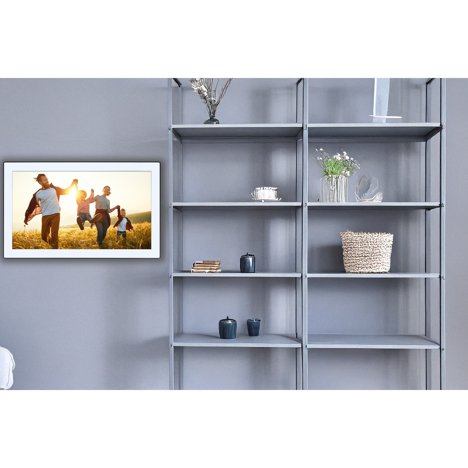 Une photo encadrée montre une famille courant dans un champ. Des étagères grises avec des objets décoratifs sont à droite.